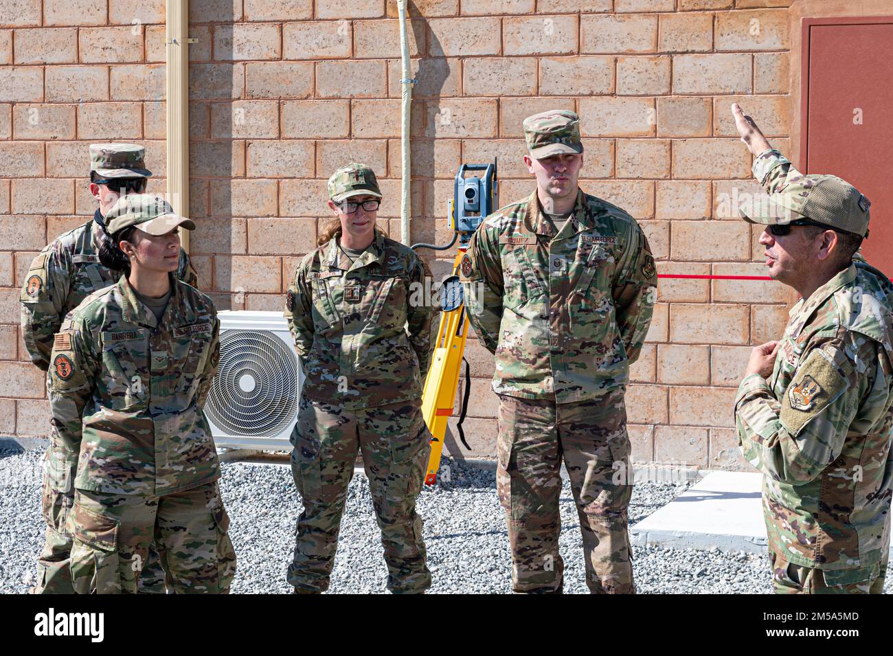 U.S. Air Force Col. John Gustafson, commander of the 386th Expeditionary Mission Support Group, talks with Airmen assigned to the Force Protection Flight, during a ribbon cutting ceremony for a new FP buillding at Ali Al Salem Air Base, Kuwait, Feb 14, 2022. This is the first permanent structure on base that coupled U.S. building standards with local standards, using a lot of local material, which decreased cost and construction time. Stock Photo