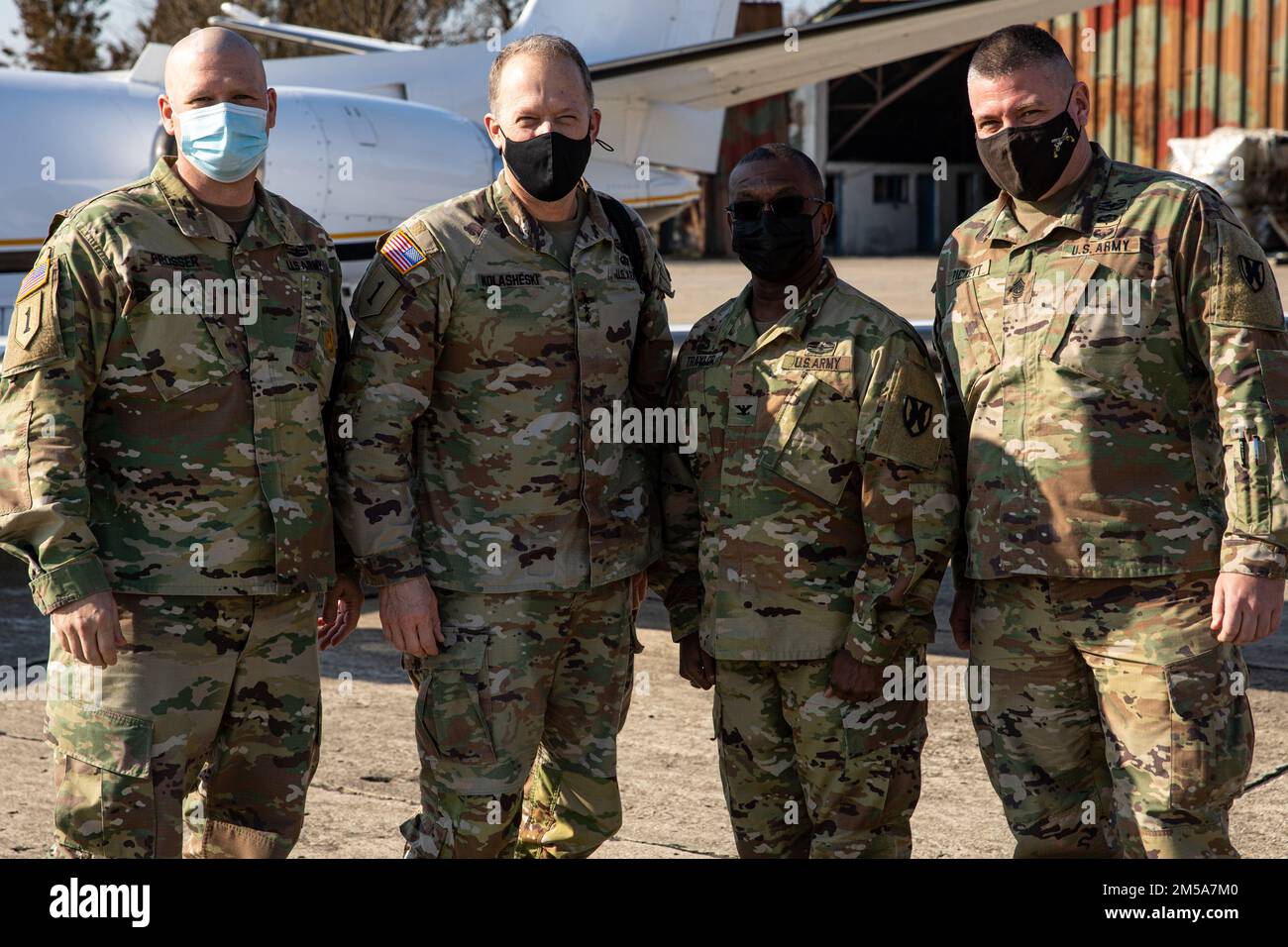 The command teams of V Corps and Area Support Group-Black Sea pose for a photo during a visit to Mihail Kogălniceanu Air Base, Romania, Feb. 15, 2022. Pictured from left to right  Command Sgt. Maj. Christopher A. Prosser, V Corps command sergeant major; Lt. Gen. John S. Kolasheski, V Corps commanding general; Col. Kendrick D. Traylor, Area Support Group-Black Sea and Command Sgt. Maj. Robert E. Pickett, command sergeant major, Area Support Group-Black Sea. V Corps enables U.S. Army Europe and Africa forces to support more exercises and training opportunities with our allies and partners, incre Stock Photo