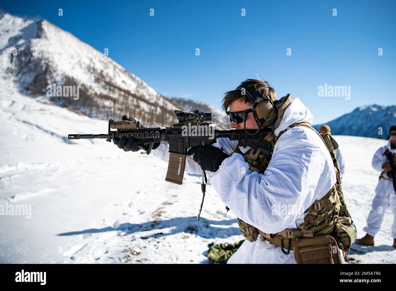 A U.S. Army paratrooper assigned to 2nd Battalion, 503rd Parachute Infantry Regiment engages targets while performing acquisition drills during an integrated marksmanship range alongside Italian soldiers from the 3rd Alpini Regiment. This training is part of Exercise Steel Blizzard at Pian dell’Alpe in Usseaux, Italy on Feb. 15, 2022.     Exercise Steel Blizzard is an Italian Army-hosted multinational mountain and arctic warfare training exercise. Three reconnaissance platoons from the 173rd Airborne Brigade take part in a three-phase training regimen with the 3rd Alpini Regiment to expand for Stock Photo