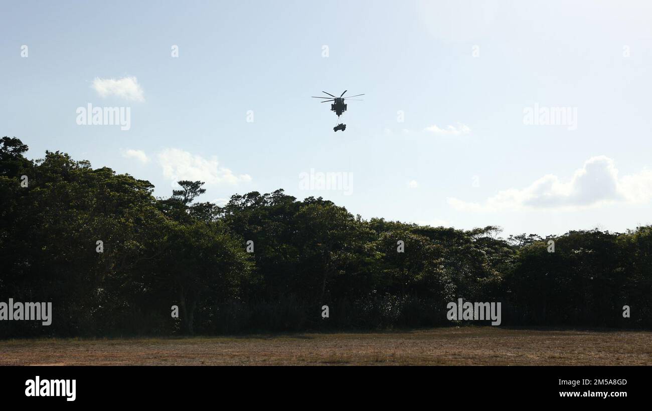 A U.S. Marine Corps CH-53E Super Stallion transports a Joint Light Tactical Vehicle during Jungle Warfare Exercise 22 in the Central Training Area, Okinawa, Japan, Feb. 15, 2022. JWX 22 is large-scale field training exercise focused on leveraging the integrated capabilities of joint and allied partners to strengthen all-domain awareness, maneuver, and fires across a distributed maritime environment. 1/3 is forward-deployed in the Indo-Pacific under 4th Marines as a part of the Unit Deployment Program. Stock Photo