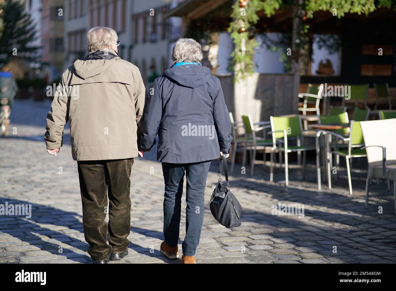 An elder couple walking down a street holding hands Stock Photo - Alamy
