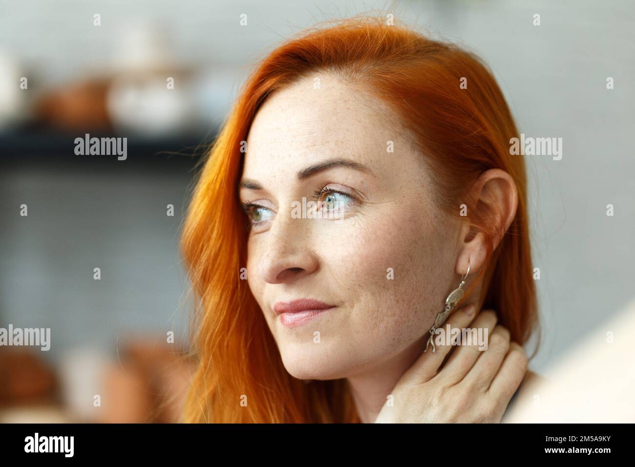 Portrait of smiling middle age woman with red hair. Stock Photo