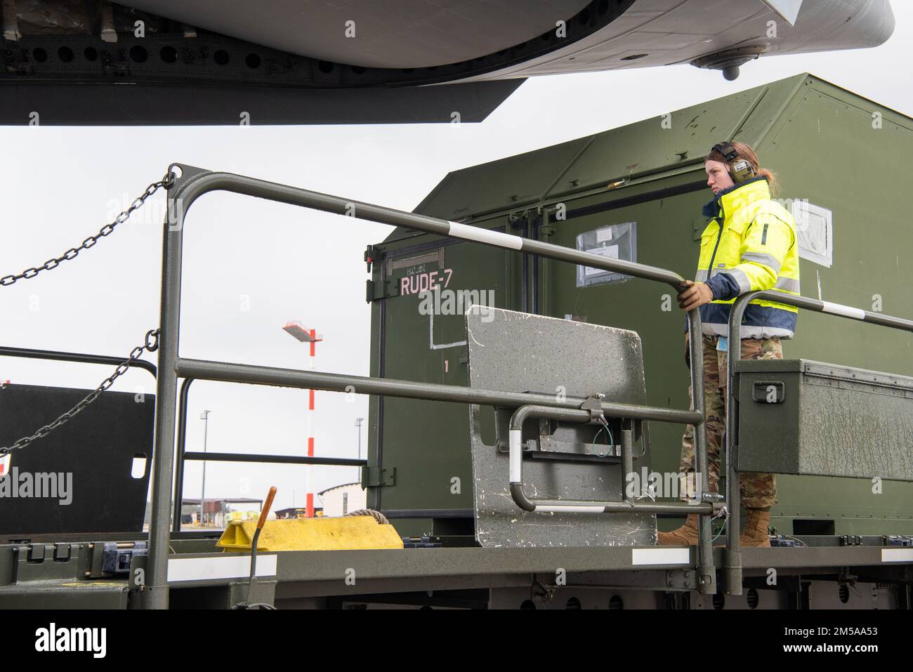 U.S. Air Force Airman Magan Jordan, 726th Air Mobility Squadron aircraft services apprentice, guides cargo as it is unloaded from a C-17 Globemaster III cargo aircraft at Spangdahlem Air Base, Germany, Feb. 15, 2022. Airmen are trained and postured to provide lethal combat power across the spectrum of military operations. Stock Photo