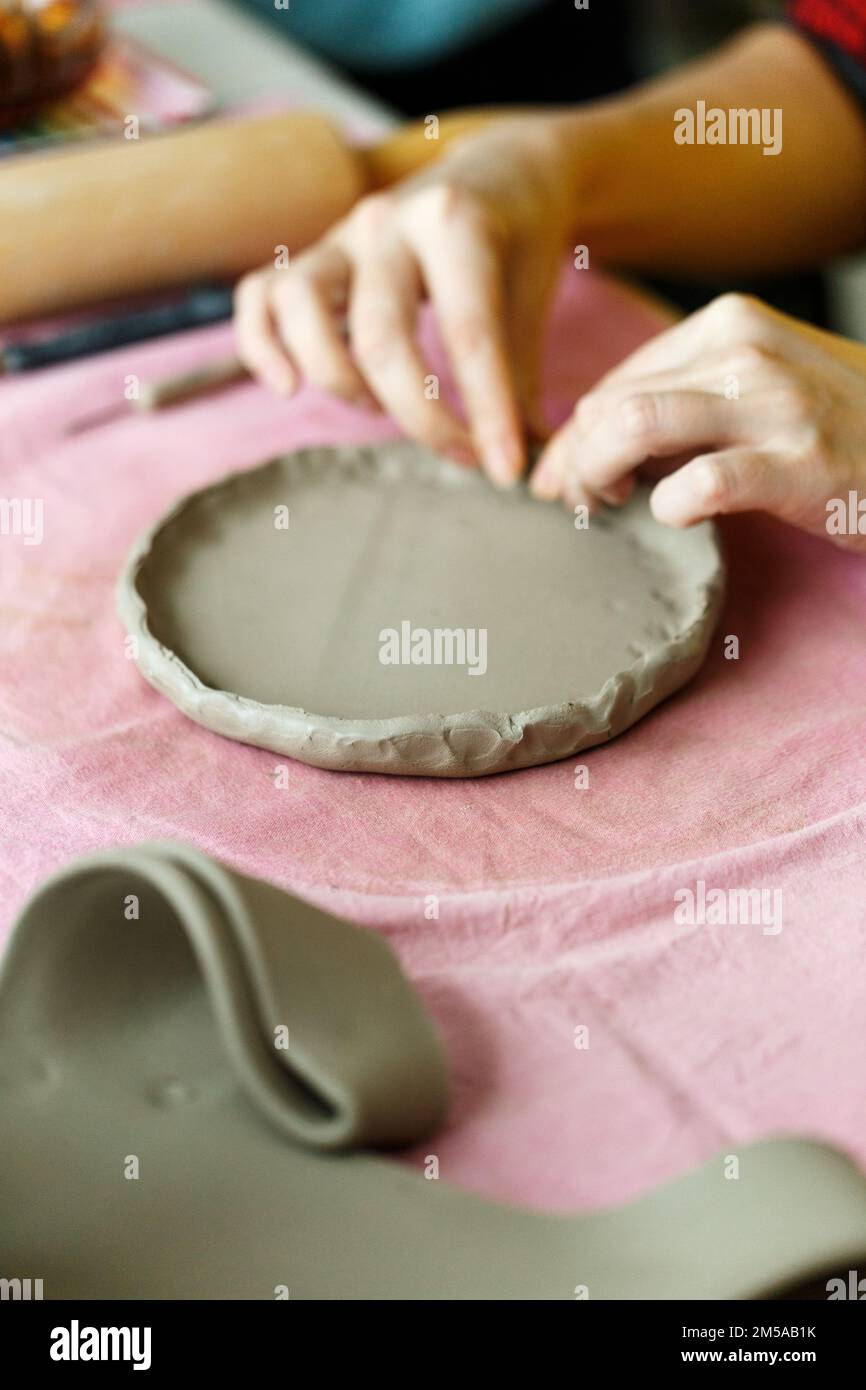 Pottery workshop class. A pottery crafts dish from a raw clay. Creating ceramics for adults Stock Photo