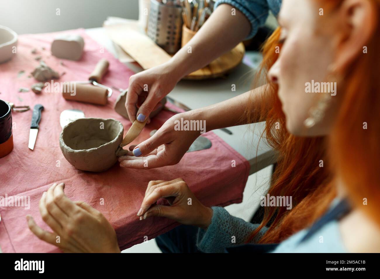 Pottery workshop class. A pottery crafts dish from a raw clay. Creating ceramics Stock Photo
