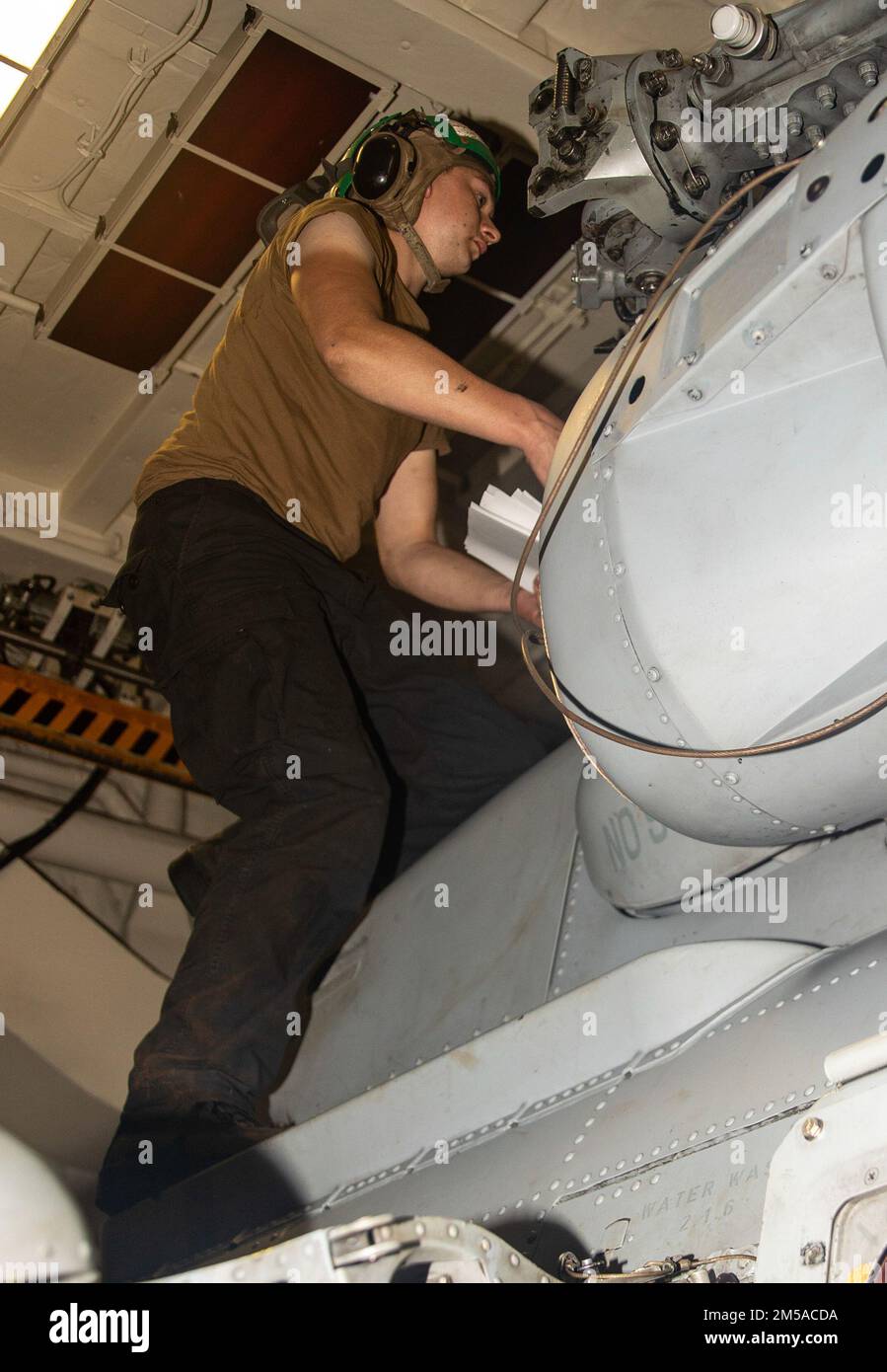SOUTH CHINA SEA (Feb. 15, 2022) Aviation Machinist Mate 3rd Class Sean Gibbens, from Texarkana, Texas, conducts maintenance on an MH-60R helicopter aboard Arleigh Burke-class guided-missile destroyer USS Ralph Johnson (DDG 114). Ralph Johnson is assigned to Task Force 71/Destroyer Squadron (DESRON) 15, the Navy’s largest forward-deployed DESRON and the U.S. 7th fleet’s principal surface force. Stock Photo