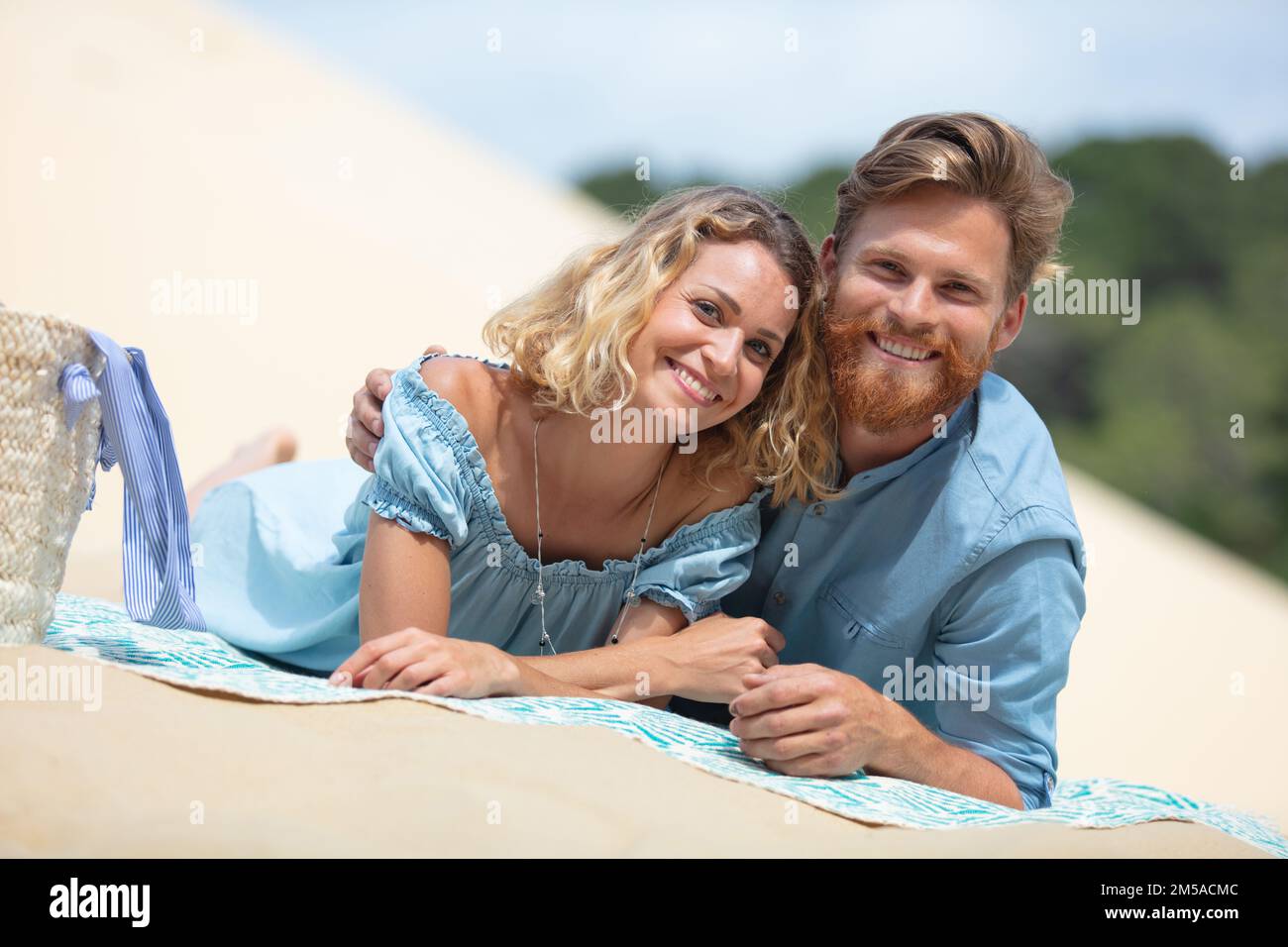 young couple laying on the beach Stock Photo - Alamy