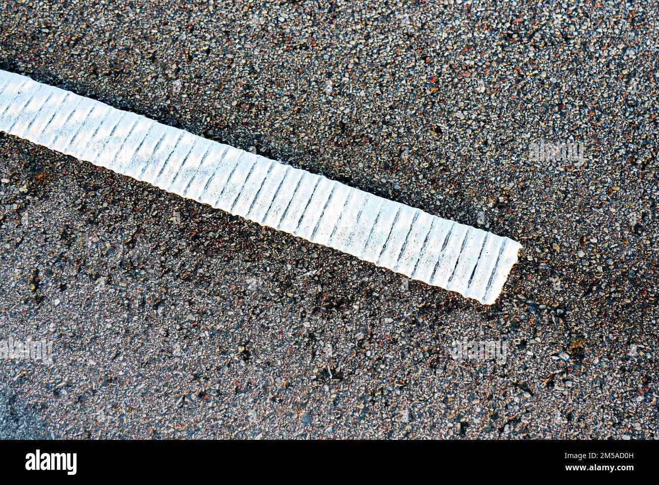 Traffic safety element, ribbed white road marking line on highway asphalt, lane border rumble