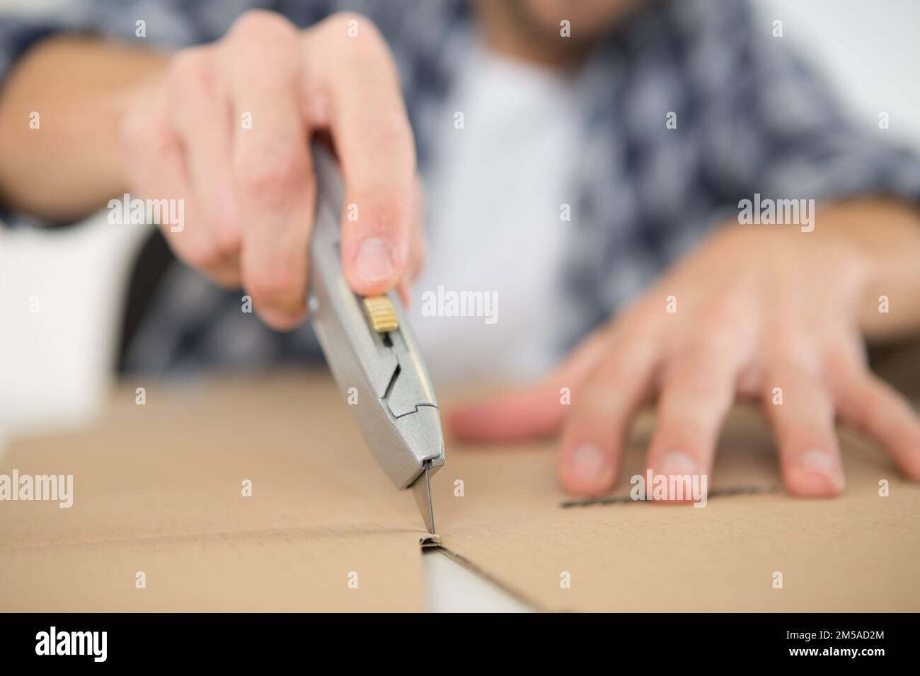 craft knife scoring a line through cardboard Stock Photo Alamy