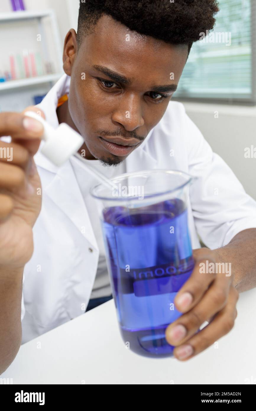 young man scientist using auto-pipette with flask in laboratory Stock Photo