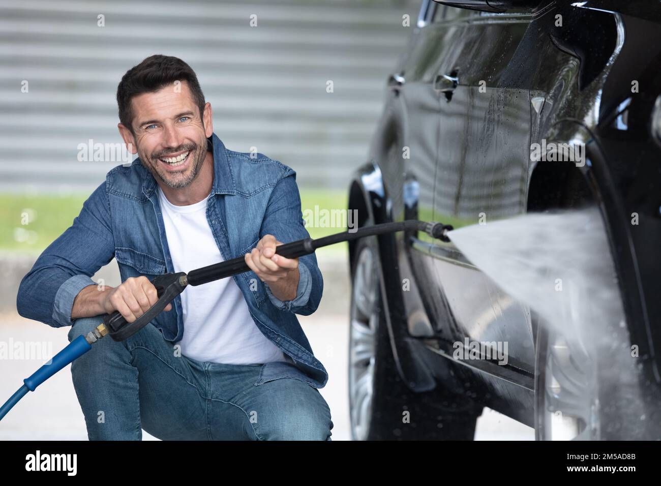 man washing car with a pressure washer Stock Photo Alamy