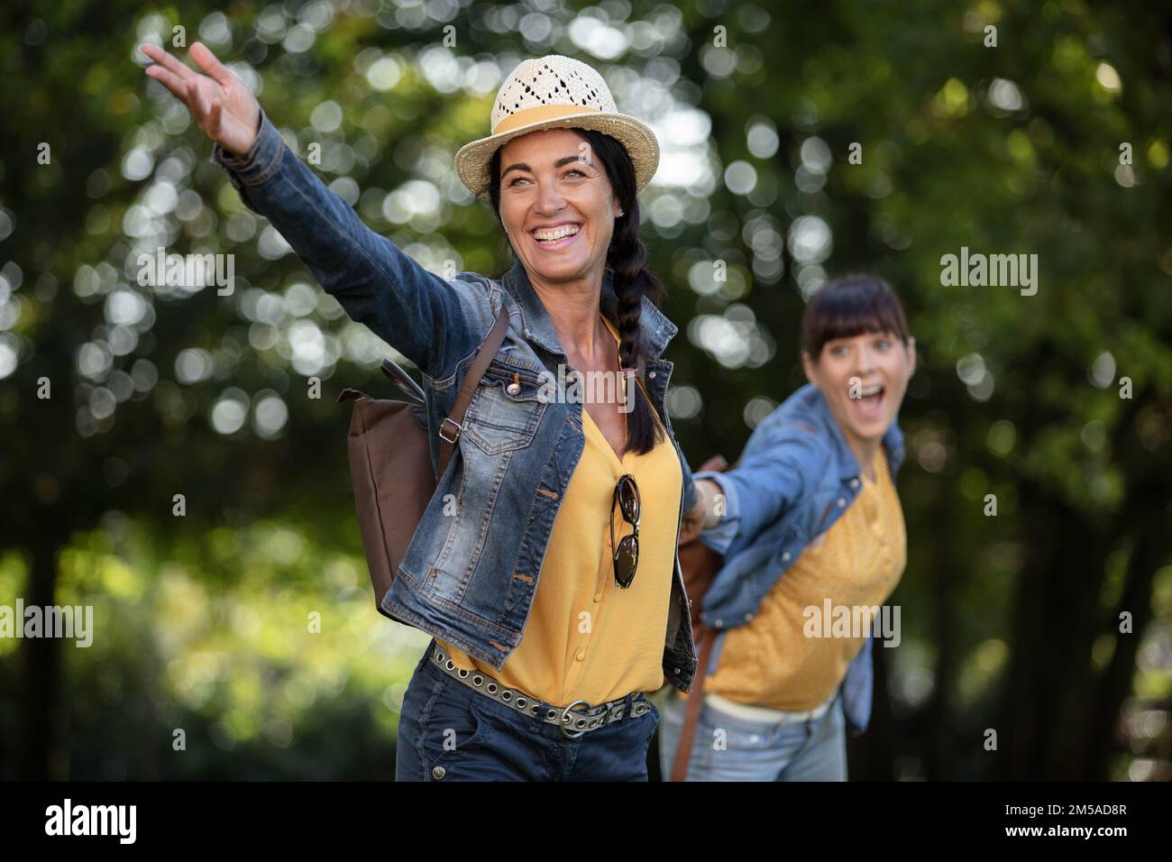 two happy girls running in nature holding hands Stock Photo - Alamy