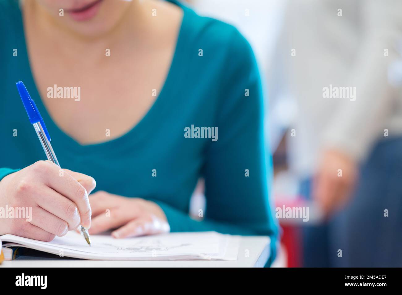university or high school student holding pencil on final exam Stock Photo