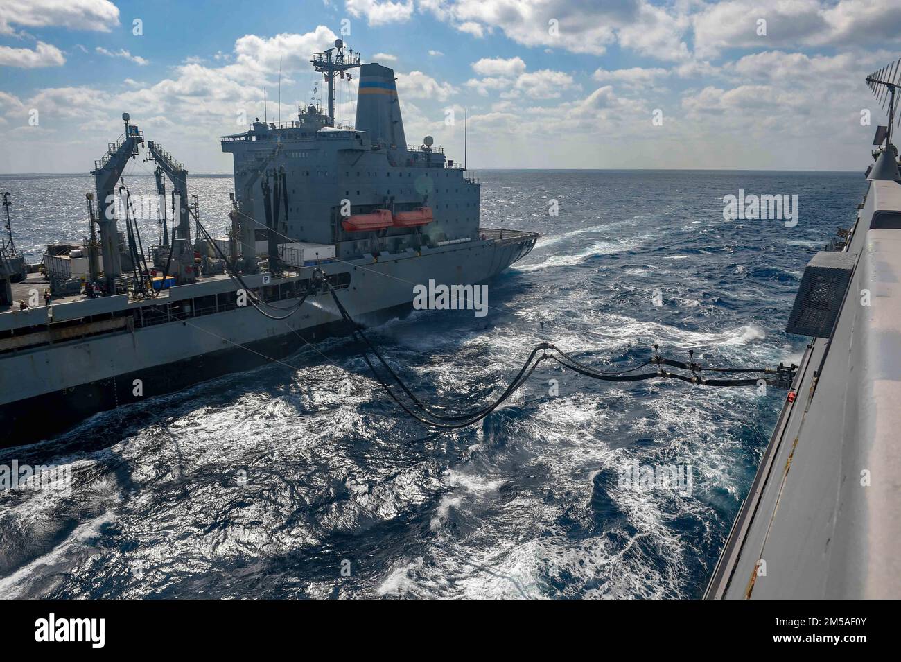 PHILIPPINE SEA (Feb. 15, 2022) The fleet replenishment oiler USNS Yukon (T-AO-202) fuels the amphibious transport dock ship USS Green Bay (LPD 20) during a replenishment-at-sea. Green Bay, part of Expeditionary Strike Group 7, along with the 31st Marine Expeditionary Unit (MEU), is operating in the U.S. 7th Fleet area of responsibility to enhance interoperability with allies and partners and serve as a ready response force to defend peace and stability in the Indo-Pacific region. Stock Photo