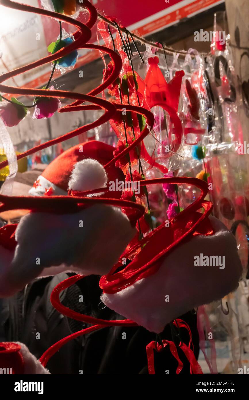 Kolkata, West Bengal, India - 25.12.2018 : Red hats and other festive gifts are being sold at roadside stall and illuminated and decorated park street Stock Photo