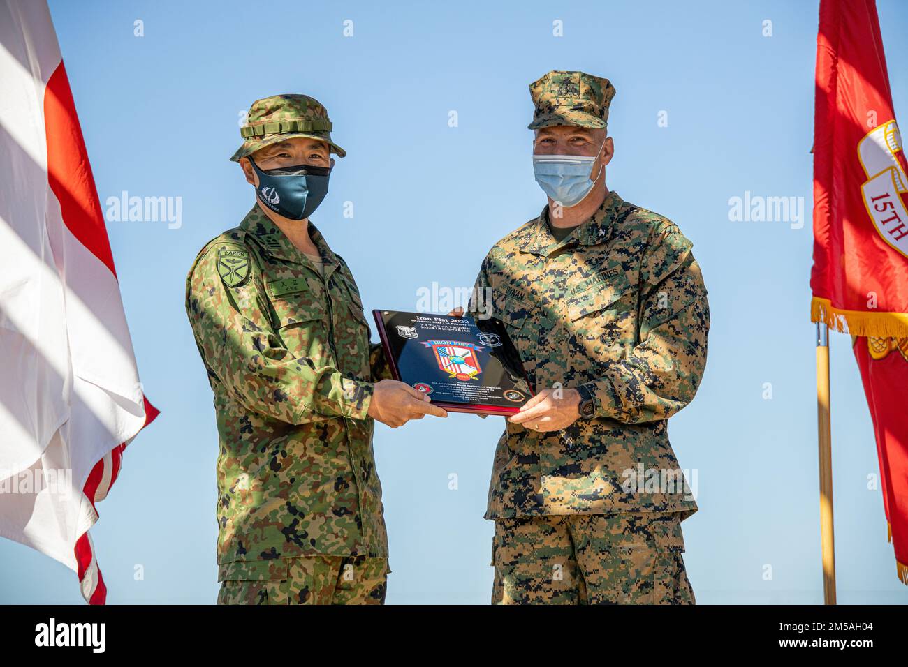 U.S. Marine Corps Col. Sean Dynan, commanding officer of the 15th Marine Expeditionary Unit, right, gifts a plaque in honor of exercise Iron Fist 2022 to Japan Ground Self-Defense Force (JGSDF) Col. Kazuhiro Irie, commanding officer of the 2nd Amphibious Rapid Deployment Regiment, during the closing ceremony of the exercise at Marine Corps Base Camp Pendleton, California, Feb. 16, 2022. For almost two decades the U.S. Marine Corps, U.S. Navy, and JGSDF have conducted exercise Iron Fist, training together in amphibious operations and affirming the U.S. commitment to our allies. Stock Photo
