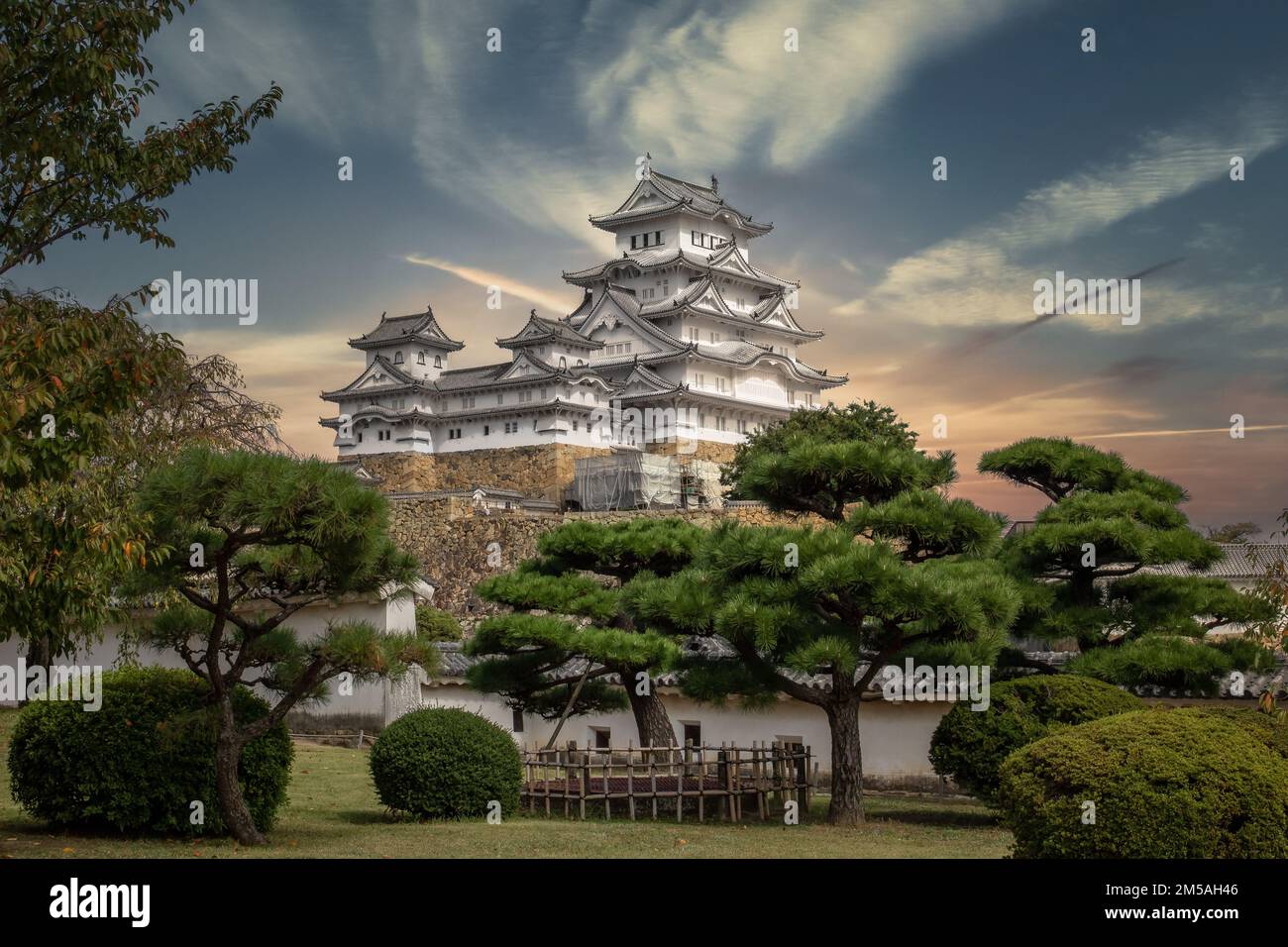 A breathtaking low-angle shot of a hilltop Japanese castle complex in ...