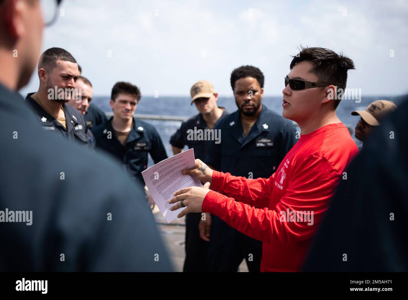 SOUTH CHINA SEA (Feb. 16, 2022) Gunner’s Mate 2nd Class Jeremy Gillentine, from Abilene, Texas, gives a safety brief before a M500 shotgun qualification course aboard the Arleigh Burke-class guided-missile destroyer USS Dewey (DDG 105). Dewey is assigned to Destroyer Squadron (DESRON) 15 and is underway supporting a free and open Indo-Pacific. CTF 71/DESRON 15 is the Navy’s largest forward-deployed DESRON and the U.S. 7th Fleet’s principal surface force. Stock Photo