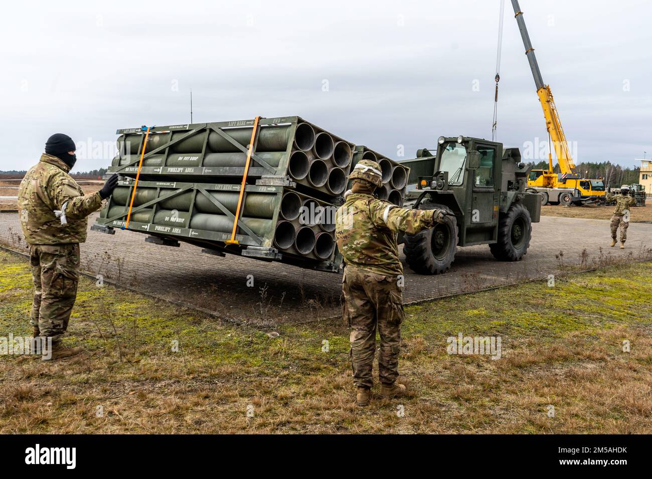 U.S. Soldiers assigned to 41st Field Artillery Brigade, offload and organize empty rocket pods in the training area of Zagan, Poland, Feb. 16, 2022. The purpose of the exercise is to test the unit's ability to transport and offload bulk shipments of ammunition to a forward area of operations. Stock Photo