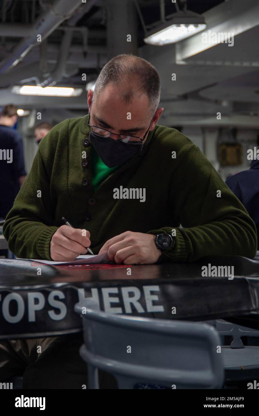 220216-N-JU123-1044 MEDITERRANEAN SEA (Feb. 16, 2022) Command Master Chief Joel Brandt, command master chief of the “Proud Warriors” of Helicopter Maritime Strike Squadron (HSM) 72, completes a menu review survey in the aft mess deck aboard the Nimitz-class aircraft carrier USS Harry S. Truman (CVN 75), Feb. 16, 2022. The Harry S. Truman Carrier Strike Group is on a scheduled deployment in the U.S. Sixth Fleet area of operations in support of naval operations to maintain maritime stability and security, and defend U.S., allied and partner interests in Europe and Africa. Stock Photo