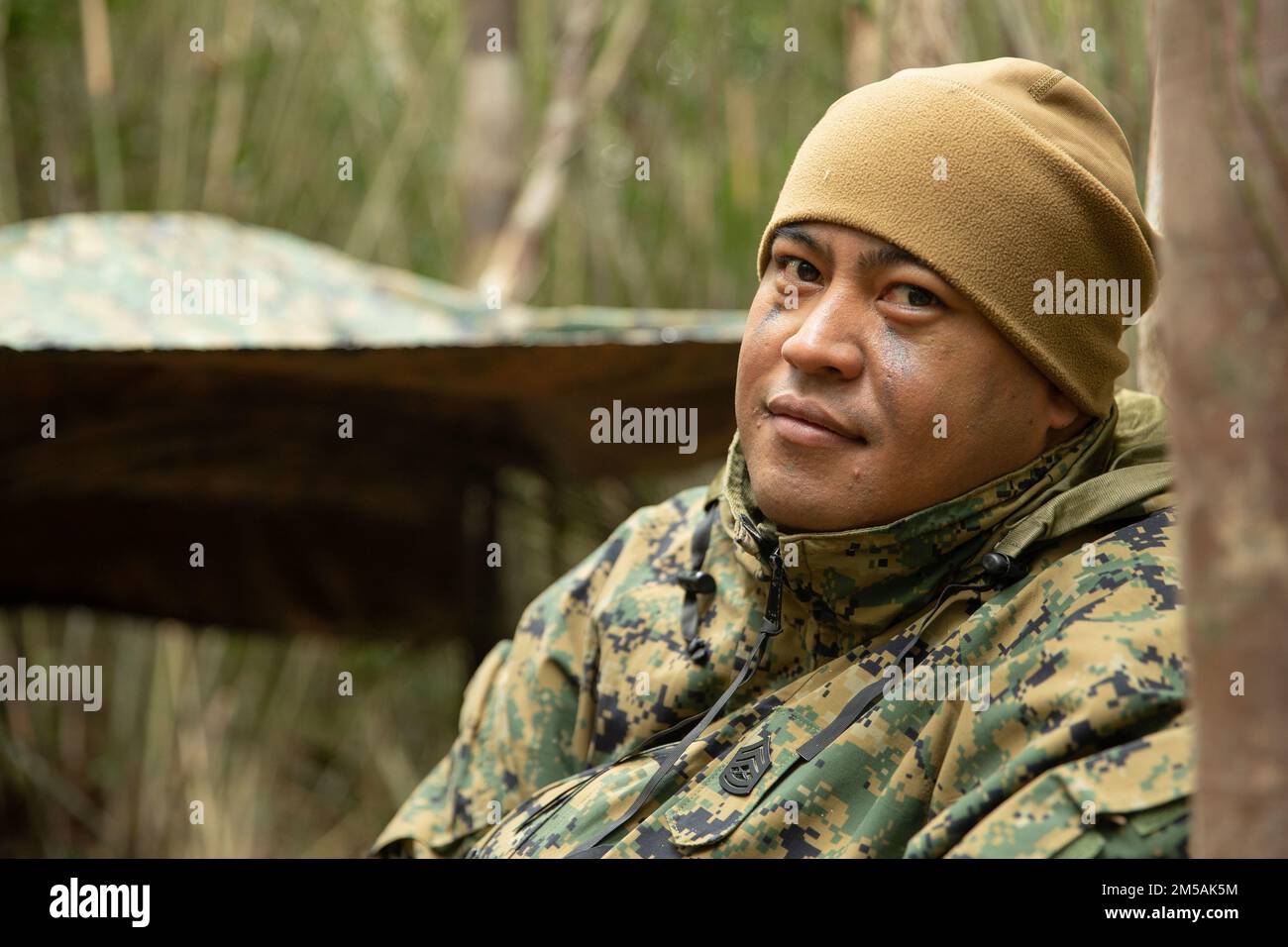 U.S. Marine Corps Gunnery Sgt. Florencio Gogo a finance technician with Combat Logistics Regiment 37, 3rd Marine Logistics Group conducts a tactical pause during Jungle Warfare Exercise 22, Feb. 16, 2022, Camp Gonsalves, Okinawa, Japan. JWX 22 is a large-scale field training exercise focused on leveraging the integrated capabilities of joint and allied partners to strengthen all-domain awareness, maneuver, and fires across a distributed maritime environment. Stock Photo