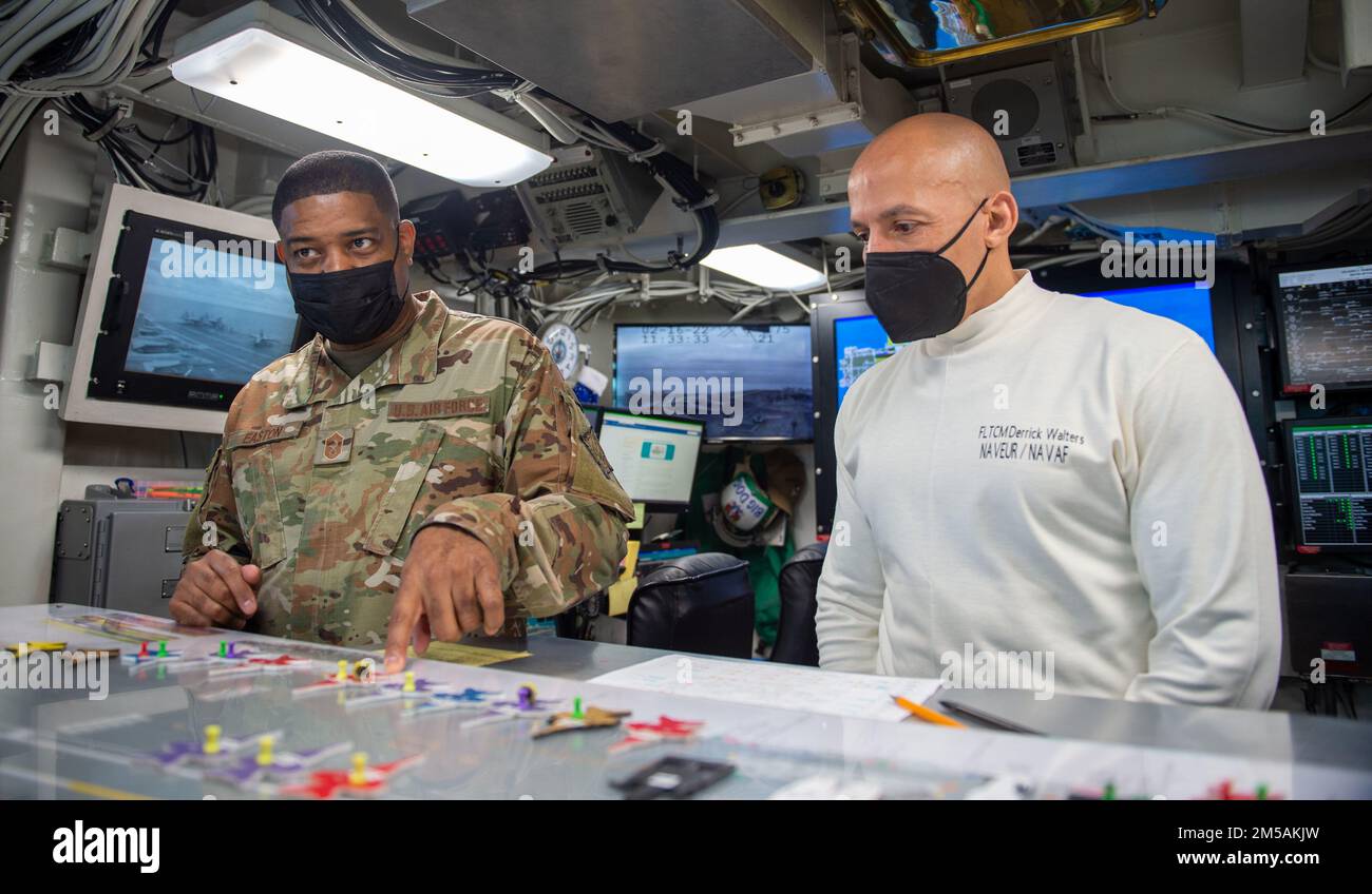 220216-N-ZE328-1454 MEDITERRANEAN SEA (Feb. 16, 2022) Chief Master Sgt. Philip Easton, chief master sergeant of U.S. European Command, left, and Fleet Master Chief Derrick Walters, fleet master chief of U.S. Naval Forces Europe and Africa, right, examine the ouija board in flight deck control aboard the Nimitz-class aircraft carrier USS Harry S. Truman (CVN 75), Feb. 16, 2022. The Harry S. Truman Carrier Strike Group is on a scheduled deployment in the U.S. Sixth Fleet area of operations in support of naval operations to maintain maritime stability and security, and defend U.S., allied and par Stock Photo