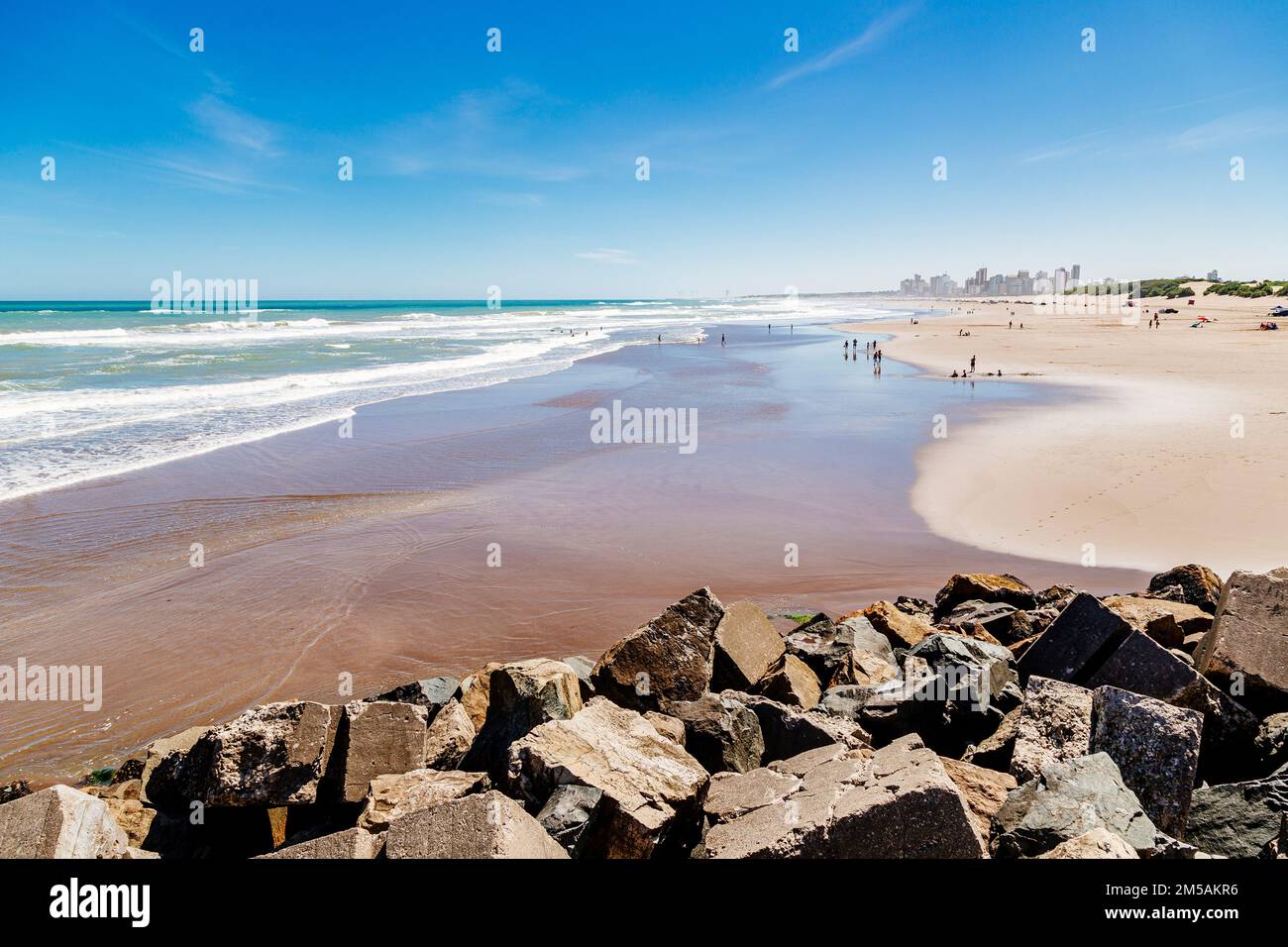 Necochea city, Buenos Aires, Argentina. View of the beach and skyline of the town. In the foreground rocks of the harbor pier. Stock Photo
