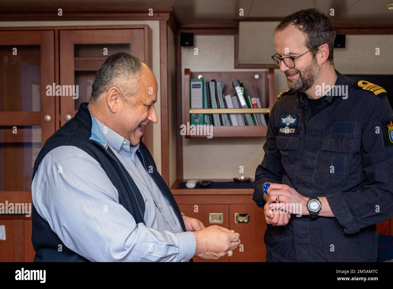 BERGEN, Norway (Feb. 16, 2022) — Secretary of the Navy Carlos Del Toro exchanges challenge coins with Norwegian Cmdr. Lars Ole Høknes, commanding officer of HNoMS Thor Heyerdahl (F314), aboard the ship in Bergen, Norway, Feb. 16, 2022. Secretary Del Toro is in Norway to visit U.S. service members and Norwegian government leaders to reinforce existing bilateral and multilateral security relationships between the U.S. Navy and the Royal Norwegian Navy. Stock Photo