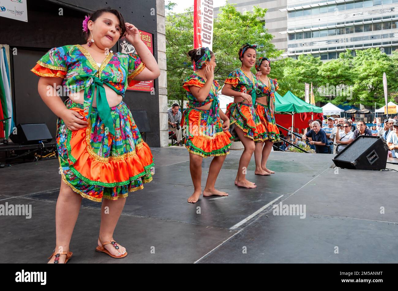 A group of female children wearing Latin American traditional clothes dance in the stage. The annual event is held in Mel Lastman square. Stock Photo