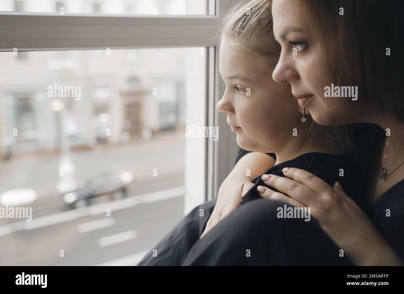 Family concept. Mom hugs her teenage daughter, together they look out ...