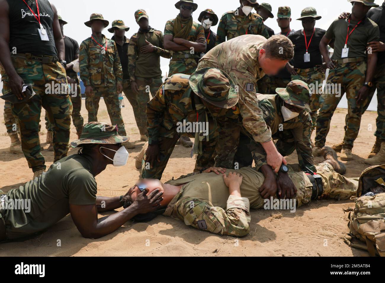 A British Armed Forces Soldier advises Ghanaian Soldiers during medical training at Exercise Flintlock, in Côte d'Ivoire on Feb. 17, 2022. Flintlock is an annual, African-led, combined military and law enforcement exercise that has strengthened key partner-nation forces throughout Africa, in partnership with international special operations forces, since 2005 Stock Photo