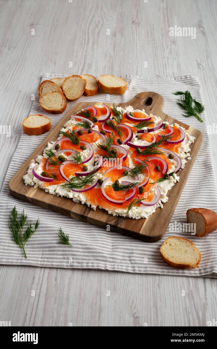 Homemade Cream Cheese Lox Bagel Board with Salmon on a white wooden