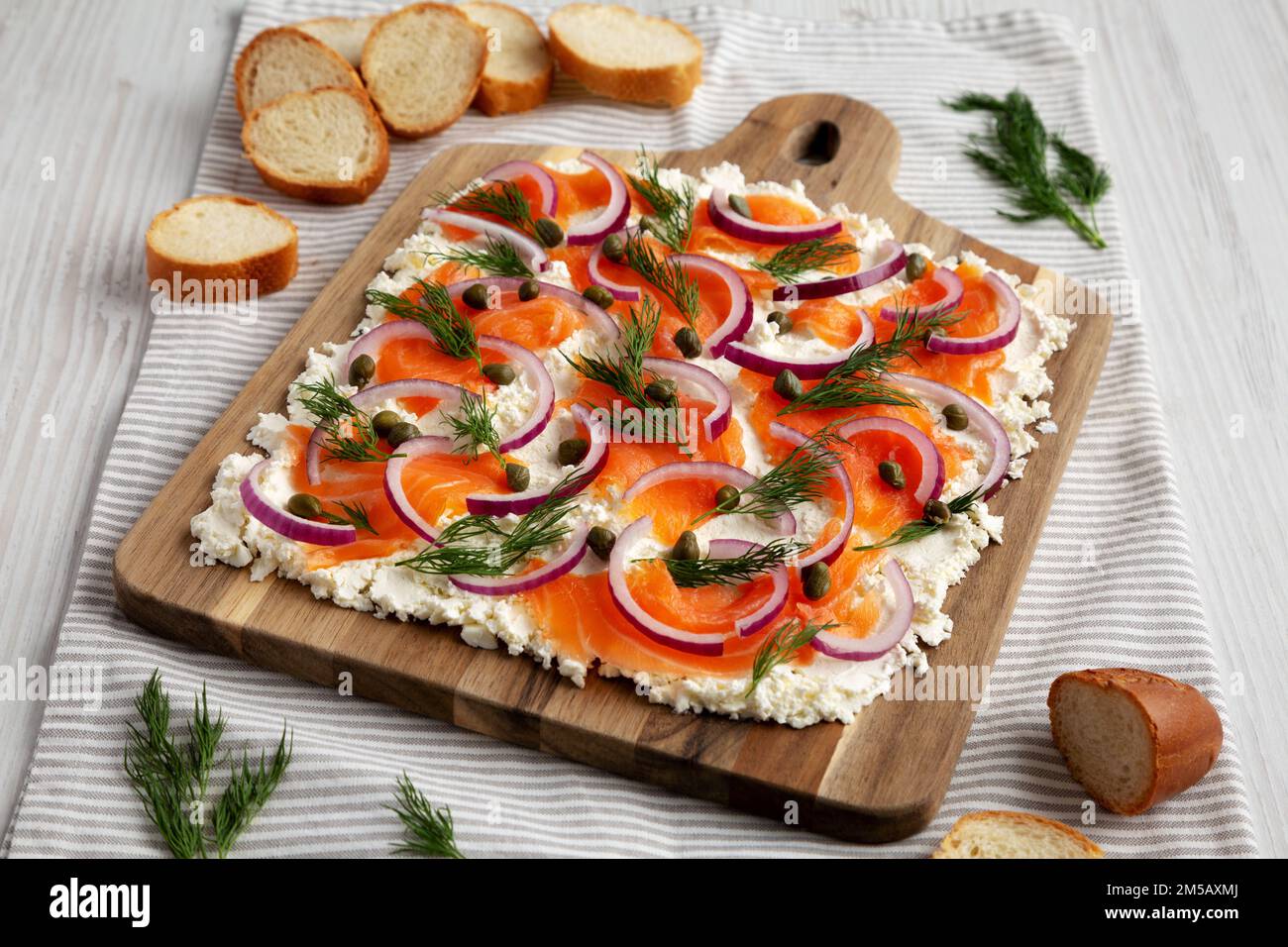 Homemade Cream Cheese Lox Bagel Board with Salmon on a white wooden