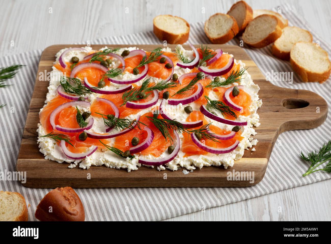 Homemade Cream Cheese Lox Bagel Board with Salmon on a white wooden