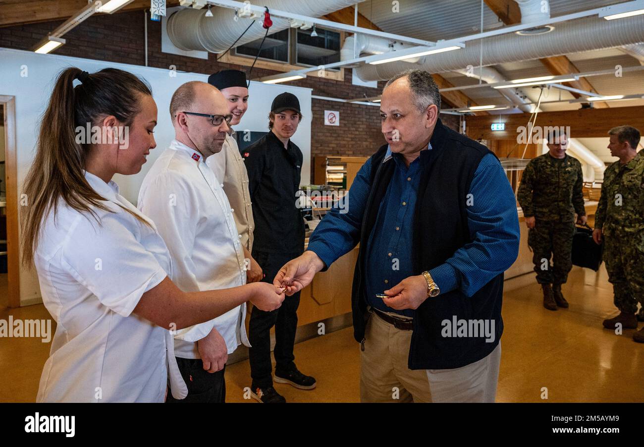 VÆRNES, Norway (Feb. 17, 2022) — Secretary of the Navy Carlos Del Toro presents challenge coins to the Norwegian chefs and staff at Værnes Garrison Chow Hall following a lunch in Værnes Feb. 17, 2022. Secretary Del Toro is in Norway to visit U.S. service members and Norwegian government leaders to reinforce existing bilateral and multilateral security relationships between the U.S. Navy and the Royal Norwegian Navy. The U.S. and Norwegian service members he meets with will participate in Exercise Cold Response 2022. Exercise Cold Response is a biennial Norwegian national readiness and defense Stock Photo