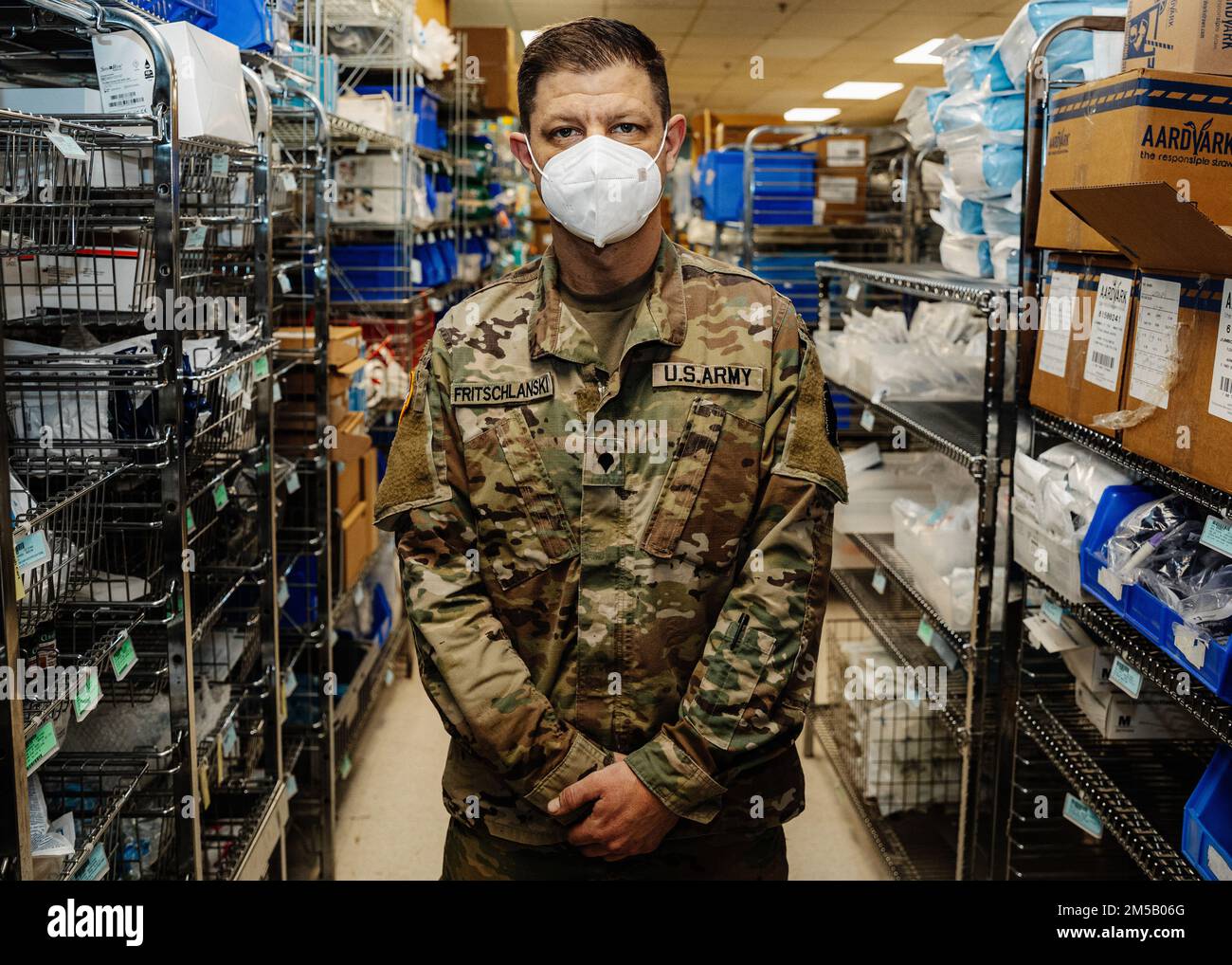 Spc. Mark Fritschlanski, an infantryman with the 1st Battalion, 175th Infantry Regiment Headquarters and Headquarters Company,  poses for a photo in the supply room at The Johns Hopkins Hospital in Baltimore, Maryland on Feb. 17, 2022. At the direction of Gov. Larry Hogan, up to 1,000 MDNG members were activated to assist state and local health officials with their COVID-19 response to include the distribution of COVID-19 test kits, 20 million KN95 and N95 masks, and other personal protective equipment and to provide support to skilled nursing facilities, hospitals, and testing sites. Stock Photo