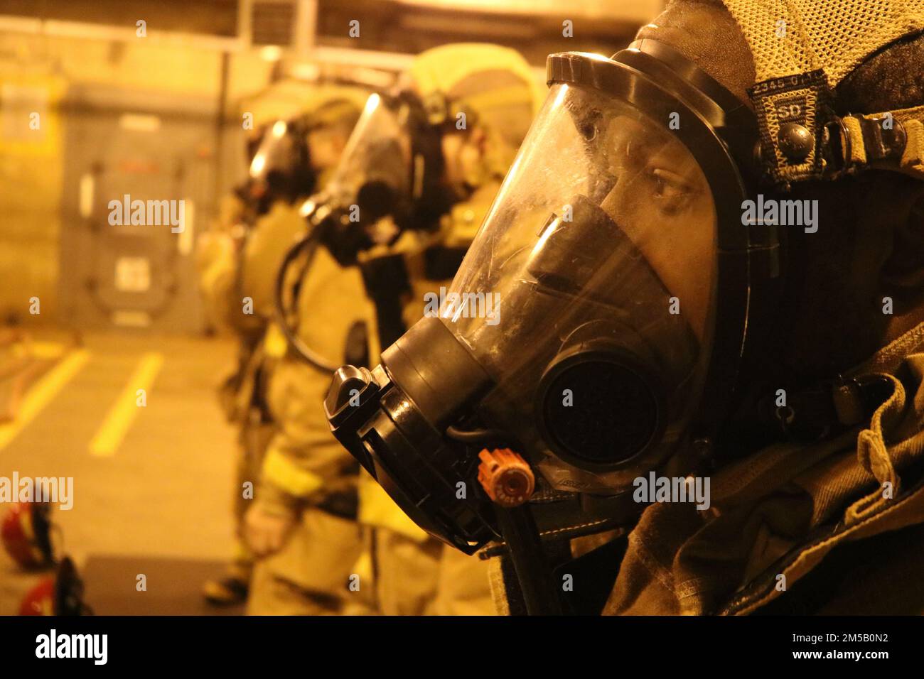 Officer Candidate School (OCS) class 08-22 students don the self-contained breathing apparatus (SCBA) during firefighting training at Officer Training Command Newport (OTCN), Rhode Island, Feb. 17. OCS morally, mentally, and physically develops civilians and fleet sailors into newly commissioned officers and imbues them with the highest ideals of honor, courage, and commitment to prepare graduates for service in the fleet as Naval officers. Stock Photo