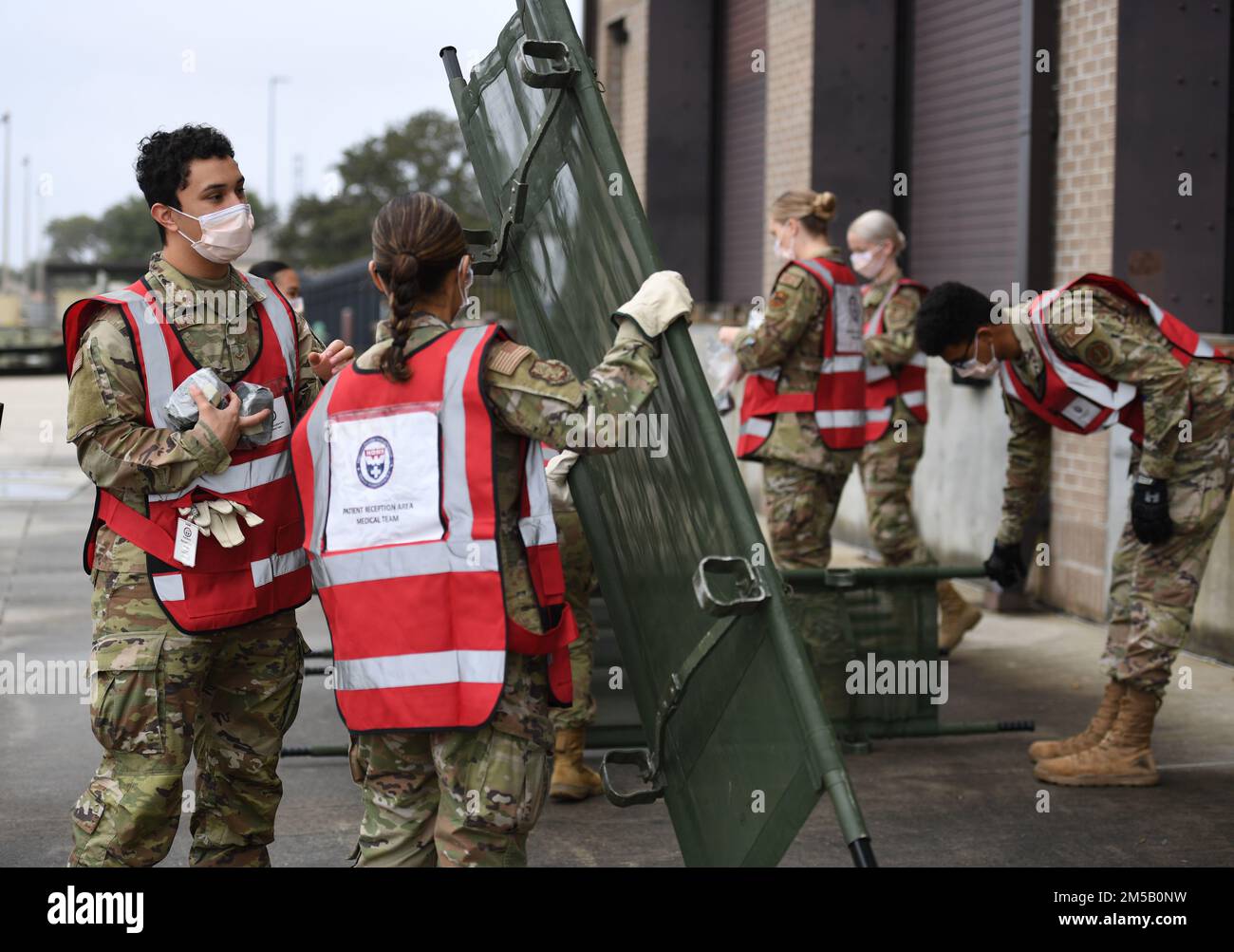 U.S Air Force Airmen 1st Class Jesse Gonzales and Elizabeth Contreras, 81st Healthcare Operations Squadron medical technicians, prepare a stretcher for patients during the National Disaster Medical System Exercise outside the 41st Aerial Port Squadron building at Keesler Air Force Base, Mississippi, Feb. 17, 2022. Keesler's Federal Coordination Center was activated and received more than 20 patients during the exercise scenario, which included the New Madrid Fault erupting, sparking an earthquake to occur in Tennessee causing extensive damage and injuring many people. Members of the 81st Medic Stock Photo