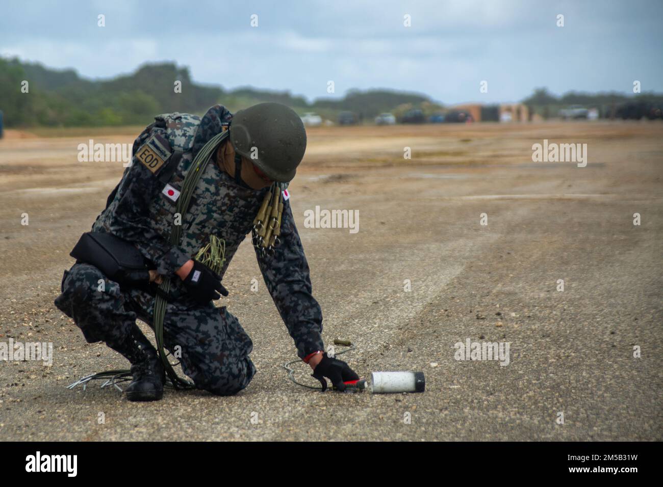 An explosive ordnance disposal technician with the Japan Air Self-Defense Force places explosive charges while conducting rapid explosive hazard mitigation training (REHM) during Cope North 2022 at Andersen Air Force Base, Guam Feb. 17, 2022. The training, hosted by the U.S. Air Forces 554th Red Horse Squadron, focuses on the rapid clearing of unexploded ordnance in response to an airfield attack allowing for safe airfield repair and continued operations. Stock Photo