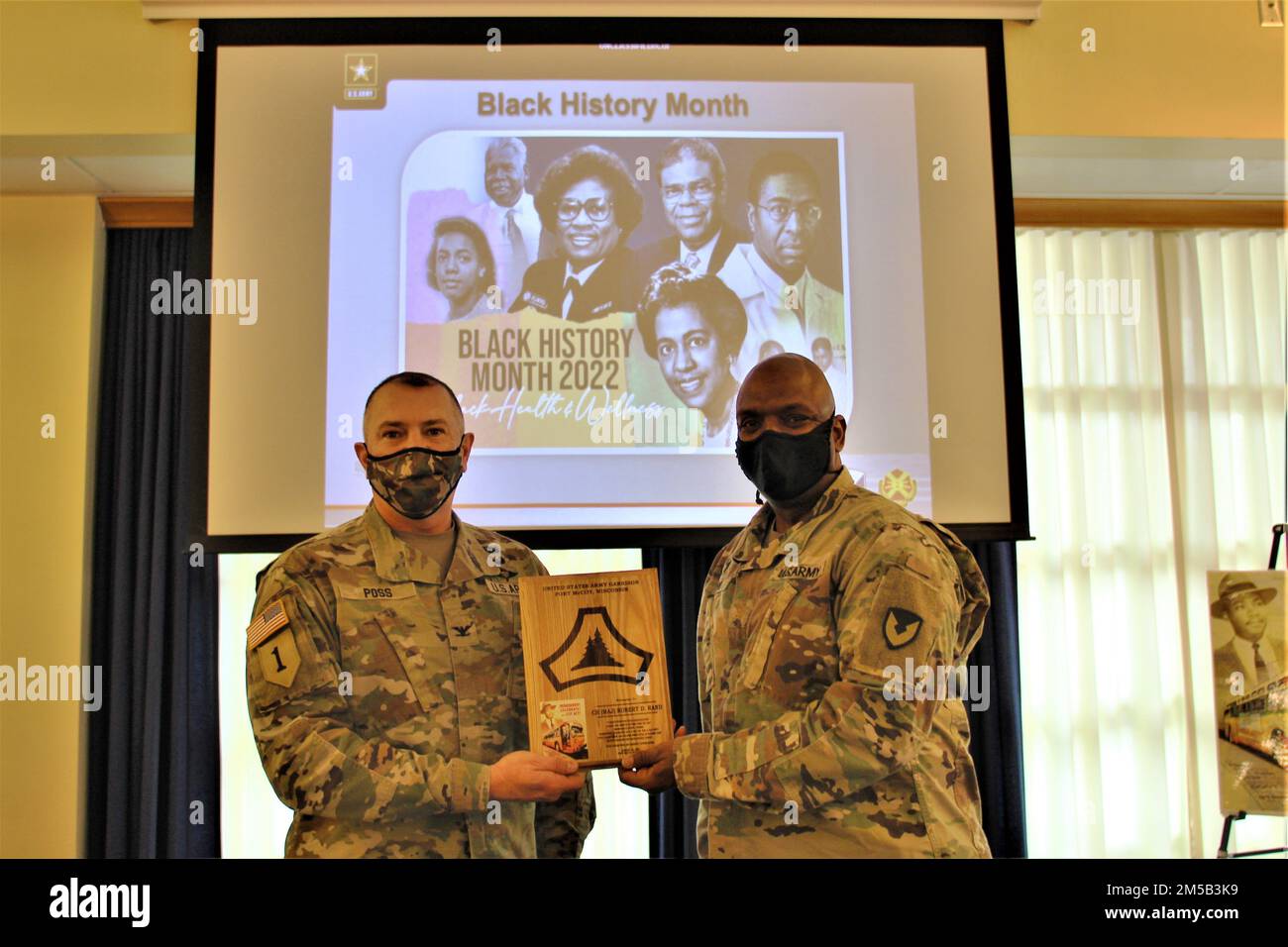 Garrison Commander Col. Michael Poss presents Chaplain (Maj.) Robert Rand, Fort McCoy Garrison chaplain, with a special appreciation plaque Feb. 17, 2022, during the 2022 Fort McCoy Black History Month observance in McCoy's Community Center at Fort McCoy, Wis. Rand was one of two speakers for the event. The observance combined the January observance for Martin Luther King Jr. Day, which was canceled at the last minute, and the February observance for Black History Month. The observance was coordinated by the Fort McCoy Equal Opportunity Office. For more information about Black History Month, v Stock Photo