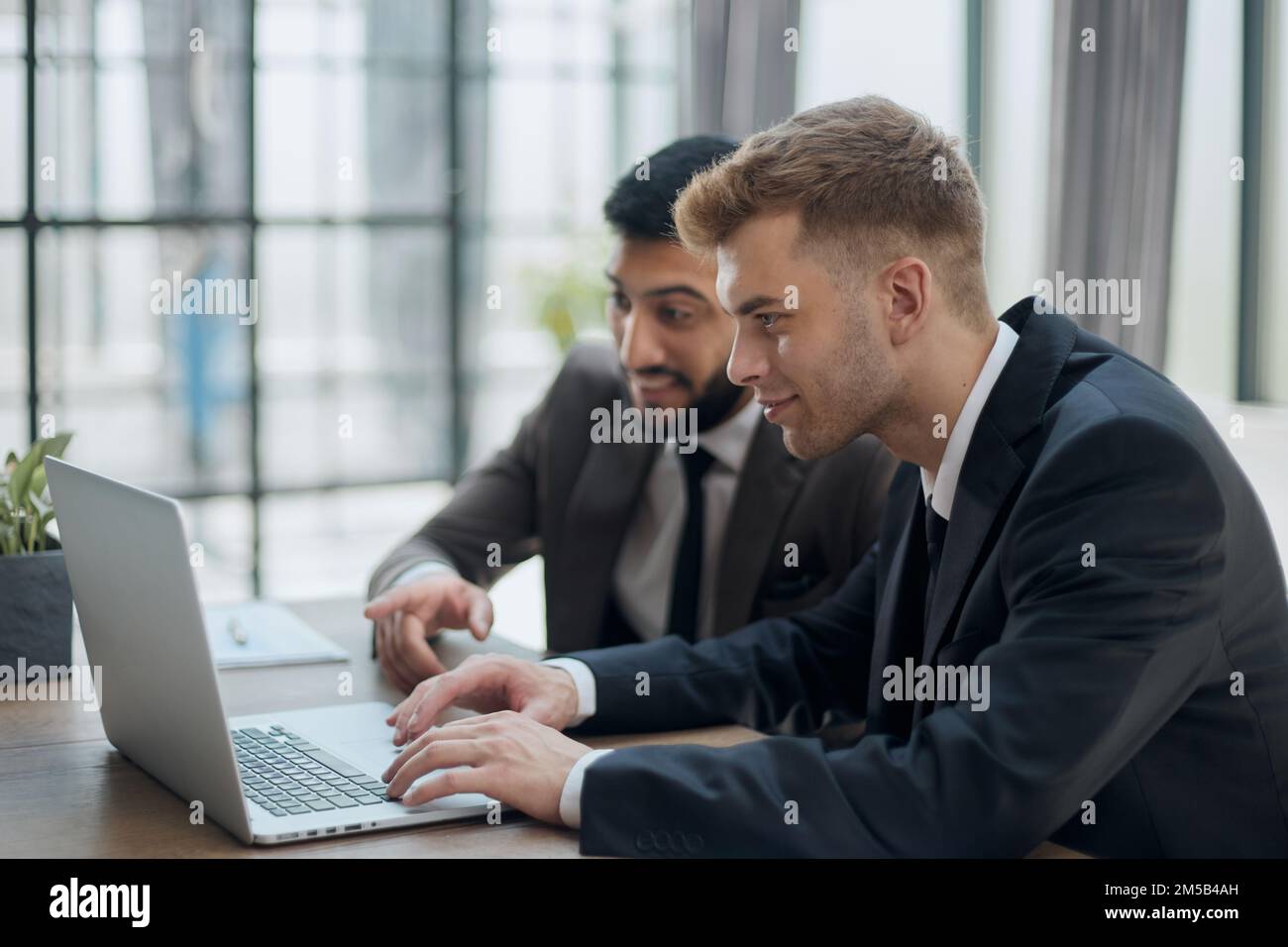 two professional businessmen discussing and using desktop computer in office Stock Photo