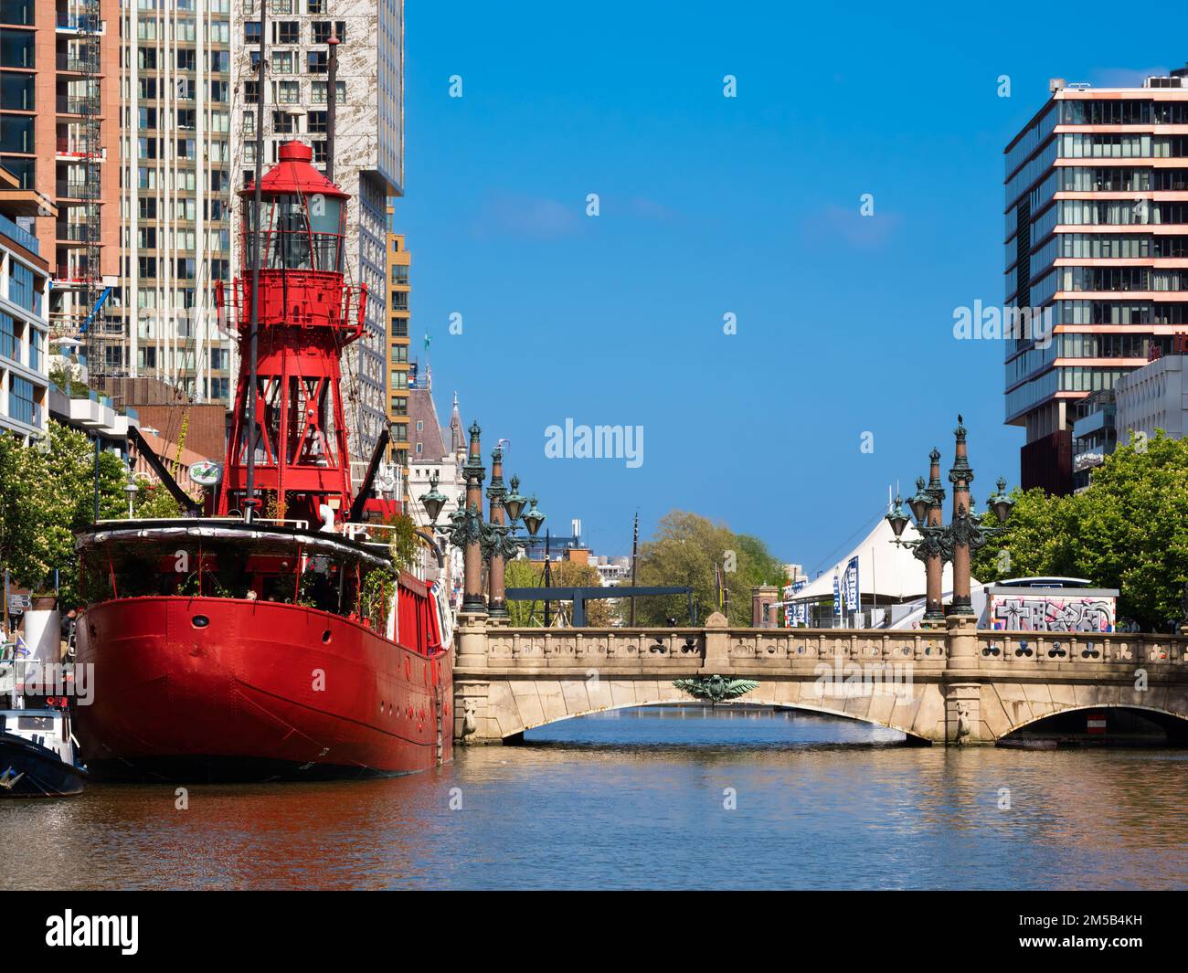 Rotterdam, Netherlands - April 28, 2022: Red ship Vesel II in Rotterdam, converted into a restaurant and modern residential buildings Stock Photo