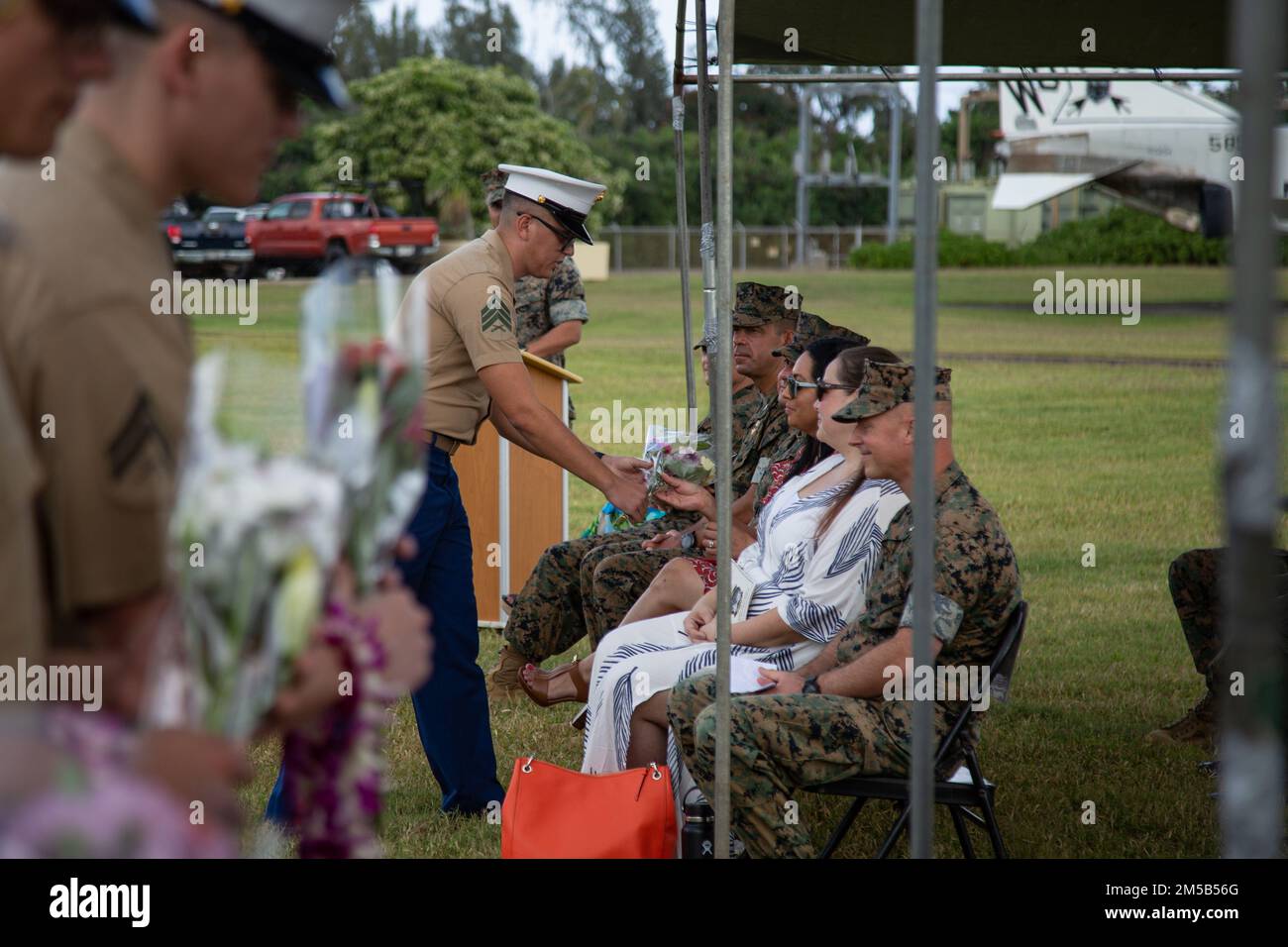 U.S. Marines with Marine Unmanned Aerial Vehicle Squadron (VMU) 3, give flowers to Sgt. Maj. Alejandro Garcia's wife as a thank you during a relief and appointment ceremony at Marine Corps Base Hawaii, Hawaii, Feb. 18th, 2022. During the ceremony Sgt. Maj. Andrew Radford relieved Sgt. Maj. Alejandro Garcia as Sergeant Major of VMU-3. The ceremony symbolizes the passing of trust and confidence from the outgoing Sergeant Major to the incoming Sergeant Major. Stock Photo