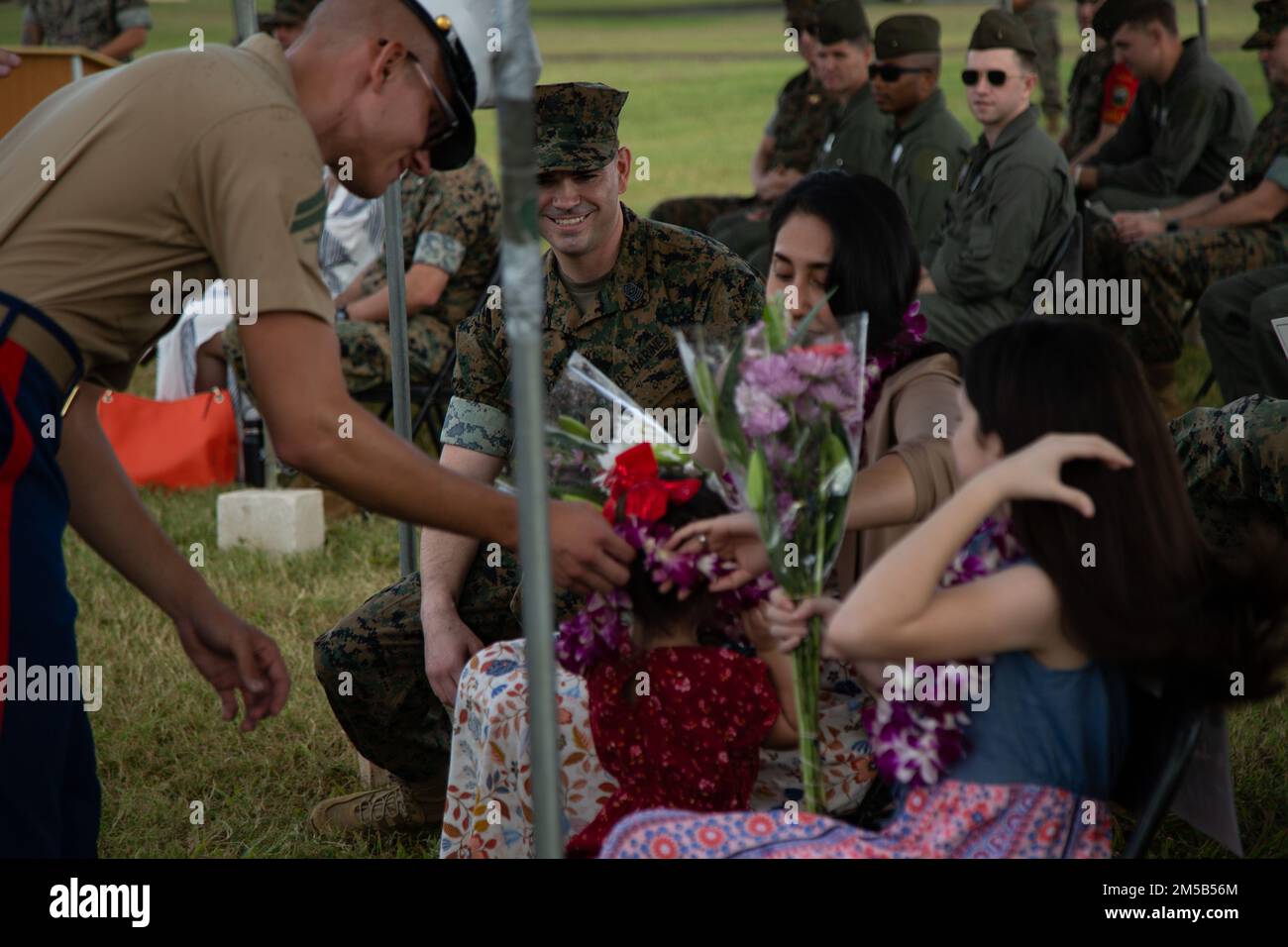 U.S. Marines with Marine Unmanned Aerial Vehicle Squadron (VMU) 3, give flowers and lei to Sgt. Maj. Andrew Radford's family as a welcome to VMU-3 during a relief and appointment ceremony at Marine Corps Base Hawaii, Hawaii, Feb. 18th, 2022. During the ceremony Sgt. Maj. Andrew Radford relieved Sgt. Maj. Alejandro Garcia as Sergeant Major of VMU-3. The ceremony symbolizes the passing of trust and confidence from the outgoing Sergeant Major to the incoming Sergeant Major. Stock Photo