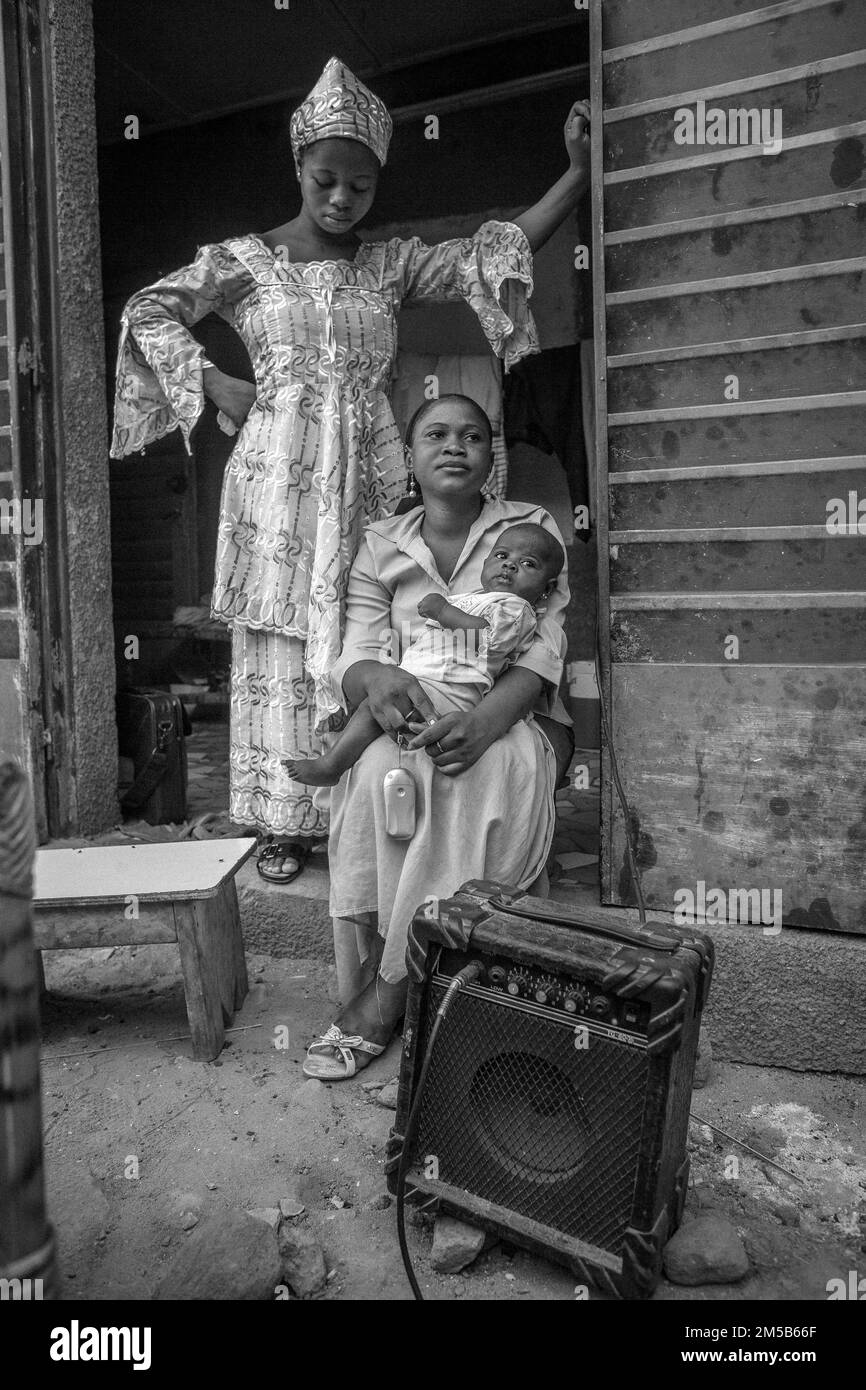 African family in traditional dress sitting next to a guitar amp in