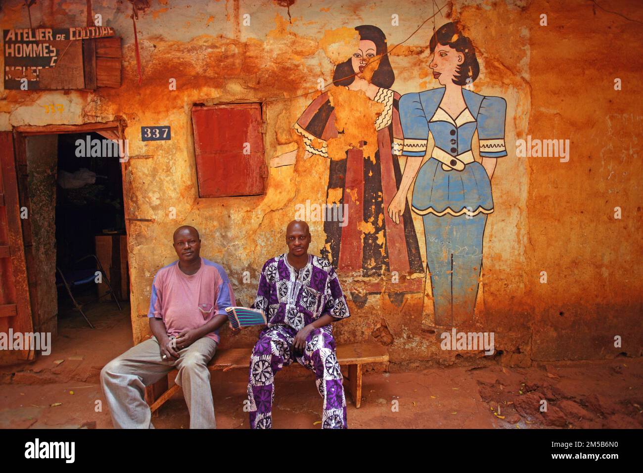 Two tailor sitting in front of their workshop and relaxing from the hot weather. Bamako , Mali , West Africa Stock Photo