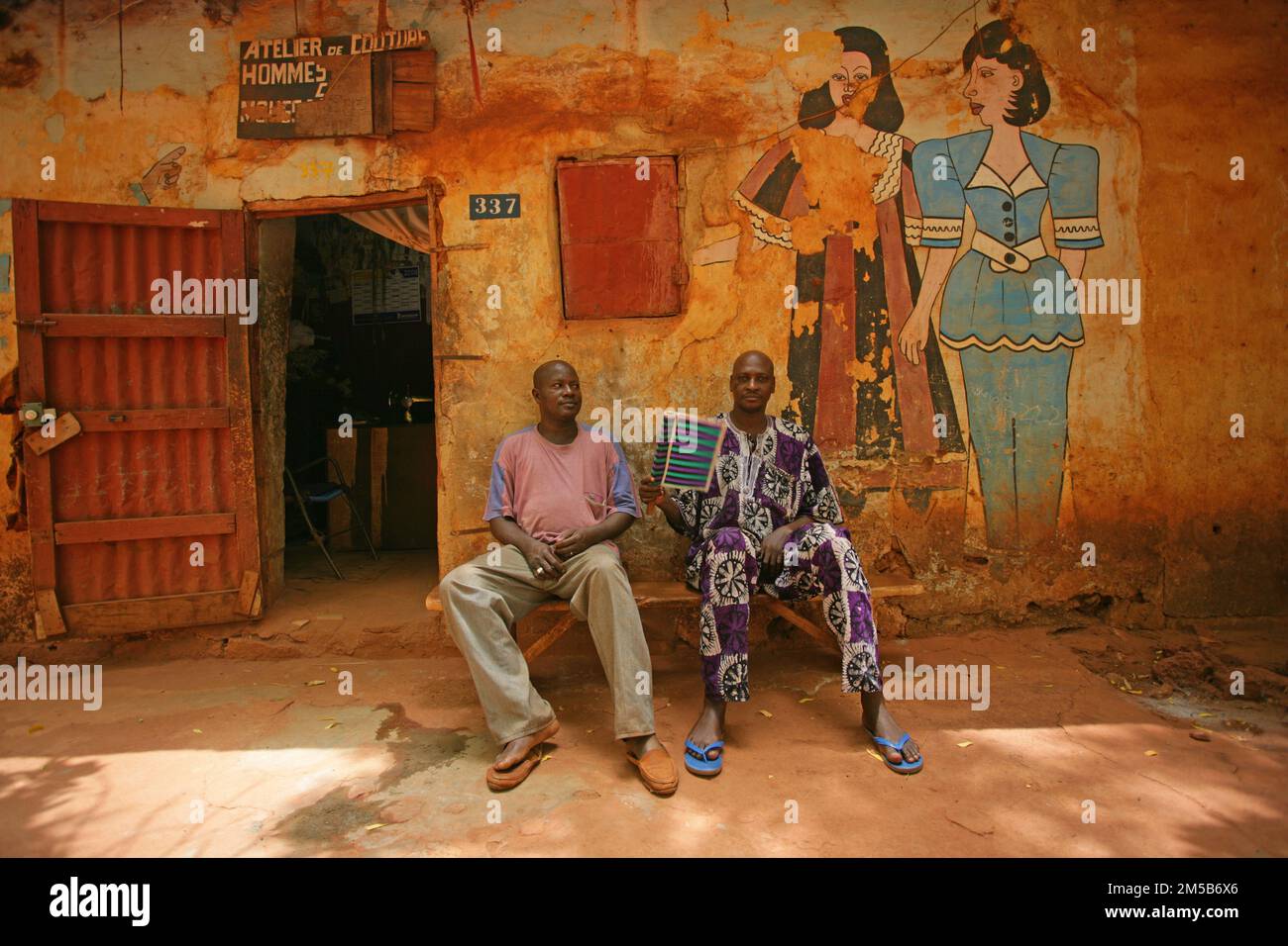 Two tailor sitting in front of their workshop and relaxing from the hot weather. Bamako , Mali , West Africa Stock Photo