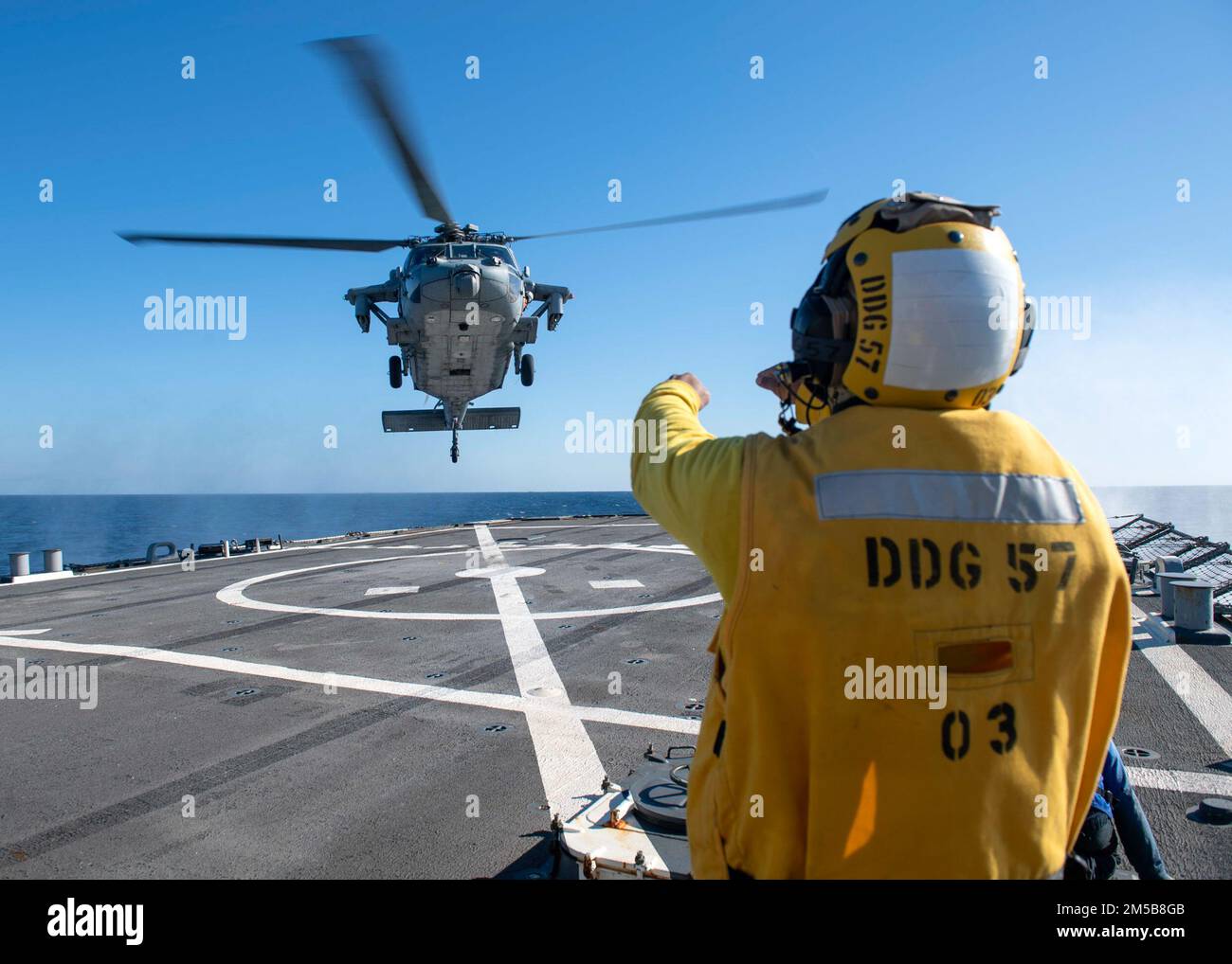 220218-N-HG846-2023 ADRIATIC SEA (Feb. 18, 2022) – Boatswain’s Mate 3rd Class Tra’shaun Cooper, from Homestead, Texas, directs a MH-60S Sea Hawk helicopter assigned to the “Dragon Slayers” of Helicopter Sea Combat Squadron (HSC-11) to land aboard Arleigh Burke-class guided-missile destroyer USS Mitscher (DDG 57), Feb. 18, 2022. Mitscher is deployed with the Harry S. Truman Carrier Strike Group on a scheduled deployment in the U.S. Sixth Fleet area of operations in support of naval operations to maintain maritime stability and security, and defend U.S., allied and partner interests in Europe an Stock Photo