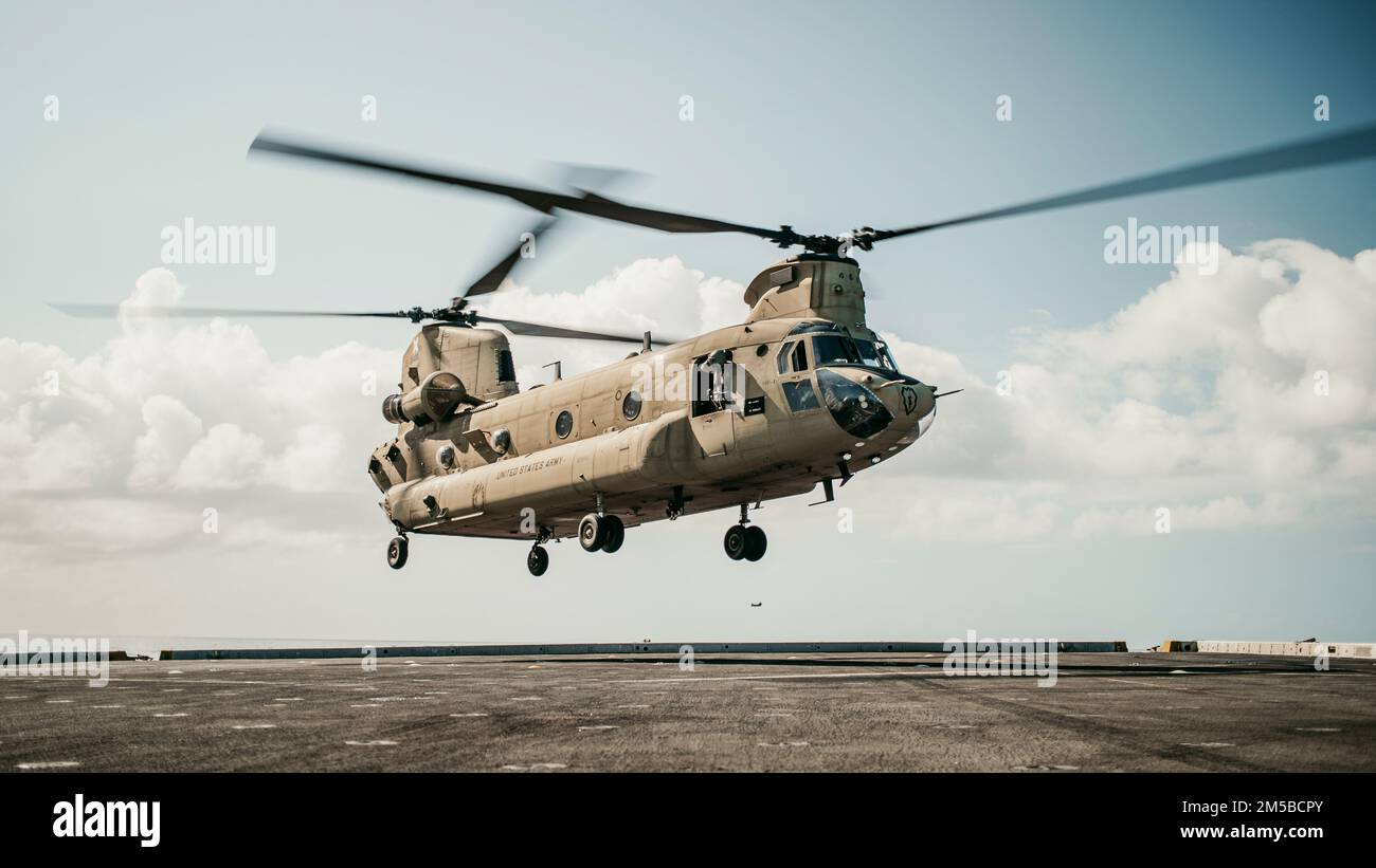 PACIFIC OCEAN (Feb. 18, 2022) A U.S. Army CH-47F Chinook attached to 3rd Battalion, 25th Aviation Regiment, 25th Combat Aviation Brigade, prepares to land on the flight deck of amphibious transport dock USS Portland (LPD 27) while conducting deck landing qualifications, Feb. 18. Marines and Sailors of the 11th Marine Expeditionary Unit and Essex Amphibious Ready Group are underway conducting routine operations in U.S. 3rd Fleet. Stock Photo