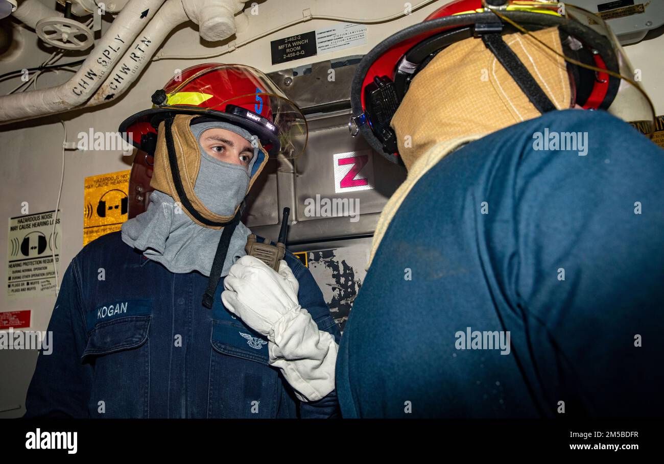 SOUTH CHINA SEA (Feb. 1, 2022) Gas Turbine Systems Technician (Electrical) 3rd Class Chris Kogan, from Ringwood, N.J., speaks over the radio during a damage control drill aboard Arleigh Burke-class guided-missile destroyer USS Ralph Johnson (DDG 114). Ralph Johnson is assigned to Task Force 71/Destroyer Squadron (DESRON) 15, the Navy’s largest forward-deployed DESRON and the U.S. 7th fleet’s principal surface force. Stock Photo